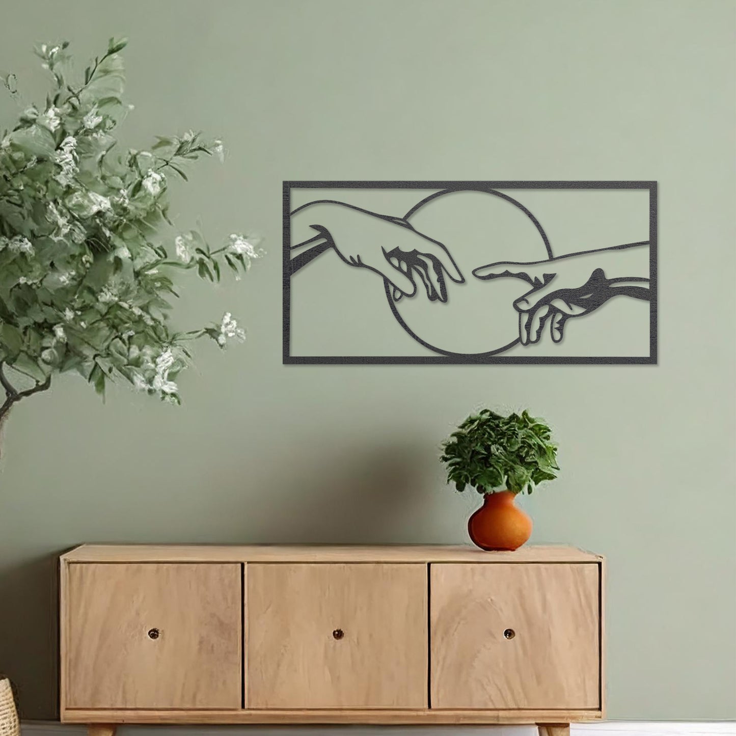 Wooden wall art featuring a minimalist depiction of two hands reaching out towards each other, framed by a circular design. Mounted on a neutral wall within modern room decor, this piece adds an artistic and meaningful touch to any space.