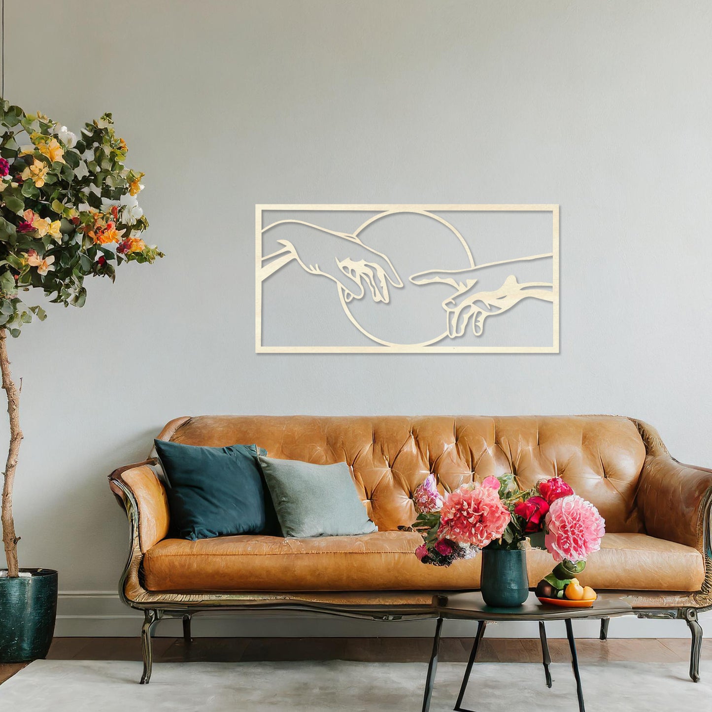Wooden wall art featuring a minimalist depiction of two hands reaching out towards each other, framed by a circular design. Mounted on a neutral wall within modern room decor, this piece adds an artistic and meaningful touch to any space.
