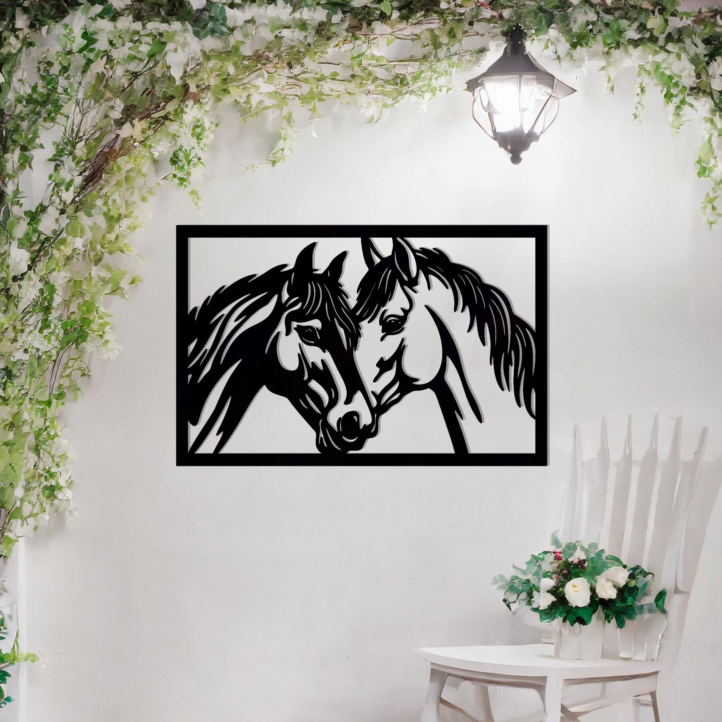 A captivating metal wall art design showcasing two horses facing each other within a rectangular frame, symbolising connection and affection. This piece beautifully complements a neutral wall in a serene and elegantly decorated outdoor space.