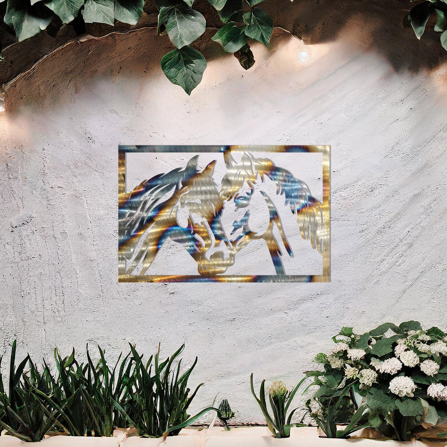 A captivating metal wall art design showcasing two horses facing each other within a rectangular frame, symbolising connection and affection. This piece beautifully complements a neutral wall in a serene and elegantly decorated outdoor space.