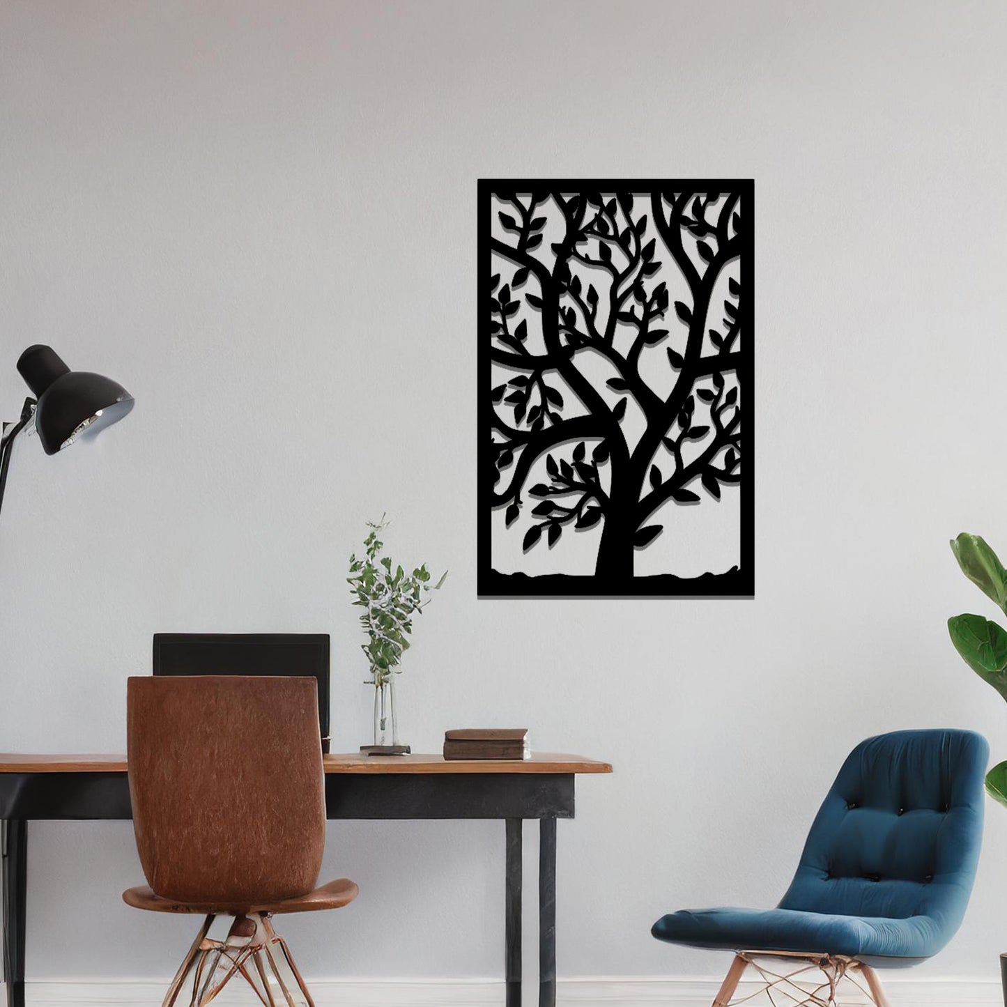Metal wall art featuring a tree with detailed branches and leaves, enclosed in a rectangular frame. The artwork is displayed on a neutral wall within a modern office space, complemented by a stylish desk, chair, and greenery.