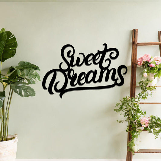 Metal wall art featuring the phrase "Sweet Dreams" in an elegant cursive font, mounted on a neutral wall within modern room decor. The artistic typography adds a charming and comforting focal point, perfect for enhancing the cosy ambiance of the space.