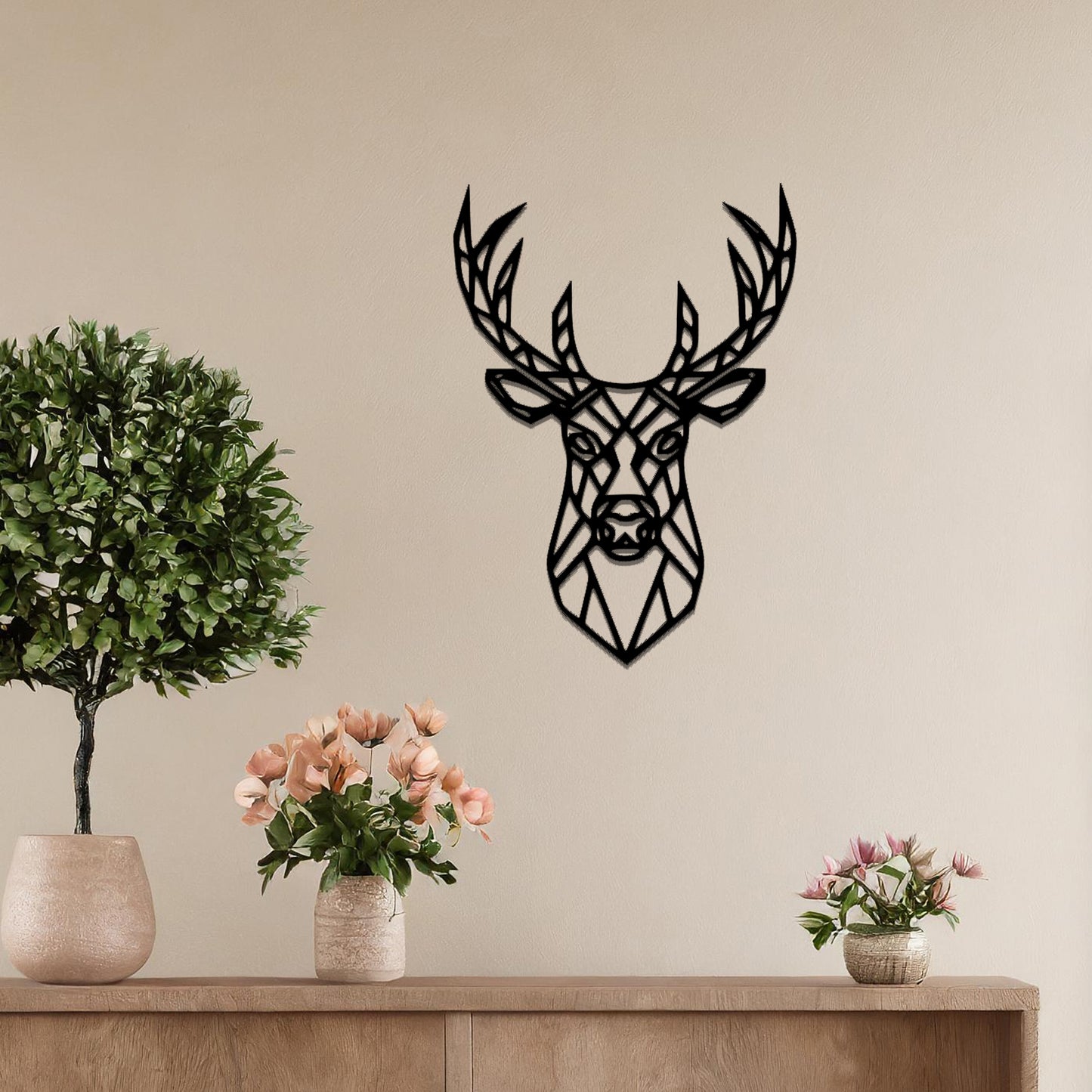 Metal wall art featuring a geometric deer head design with intricate detailing, crafted with precise laser-cut techniques, displayed on a neutral wall within modern decor.