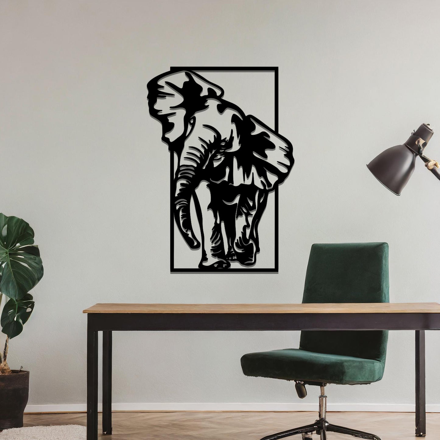 Metal wall art featuring a detailed silhouette of an elephant walking, framed by a rectangular border. The art is placed on a neutral wall in a modern office setting, adding a dynamic and nature-inspired element to the workspace decor.