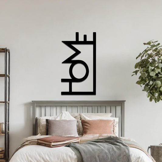 A modern metal wall art design featuring the word "HOME" in bold, geometric typography with an innovative, angular twist. The artwork is displayed on a neutral wall in a contemporary room setting.