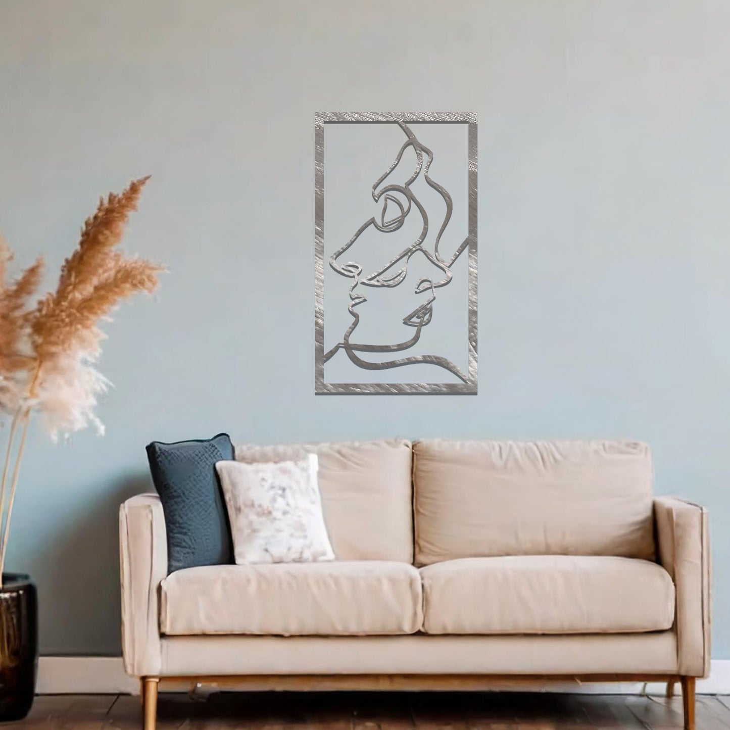Metal wall art featuring an abstract design of two faces in profile, formed with flowing lines. The art is placed on a neutral wall within a modern office setting, contributing to a stylish and contemporary atmosphere.