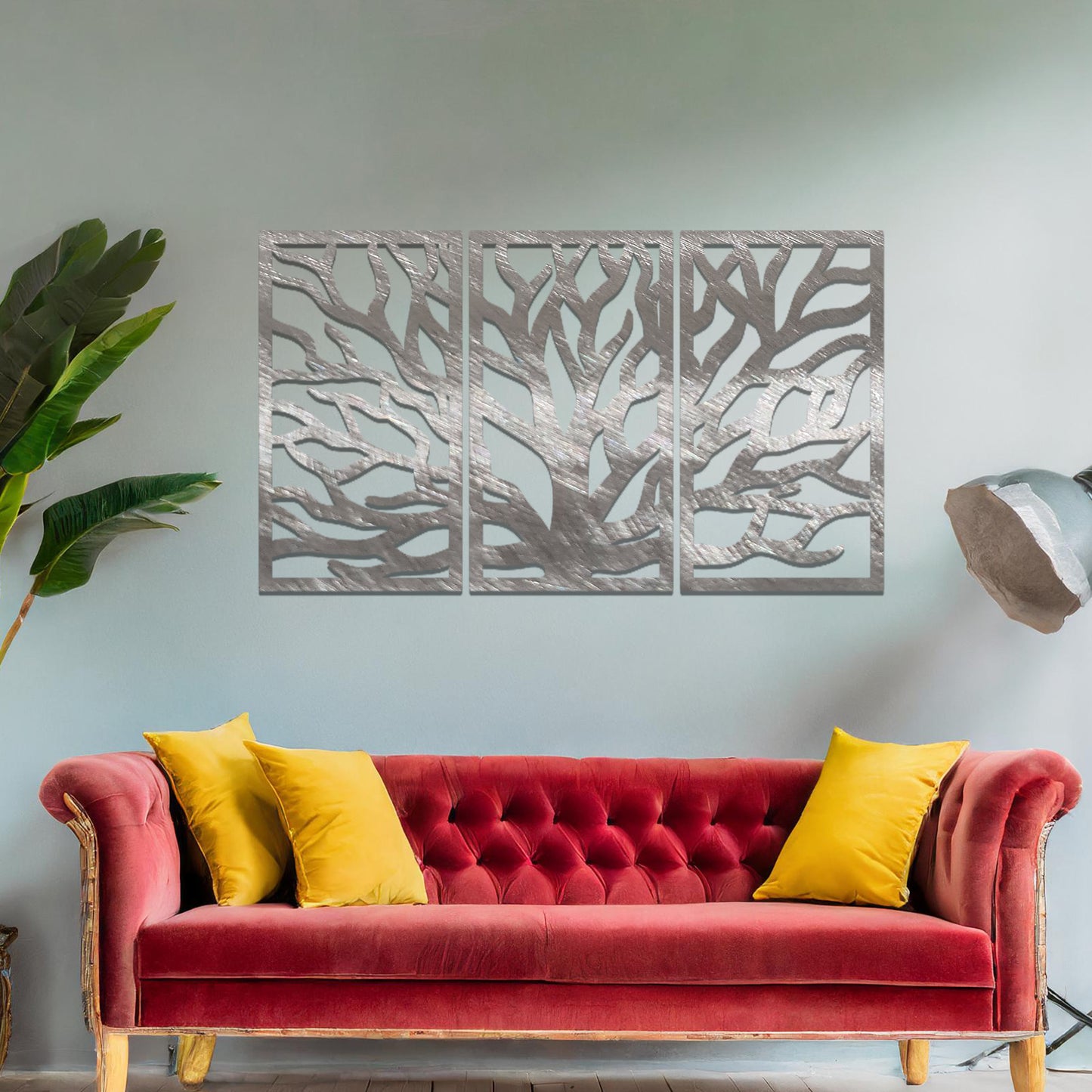 Metal wall art featuring a three-panel design of a tree with intricate branching patterns, crafted with precise laser-cut detailing, placed on a neutral wall within modern decor.