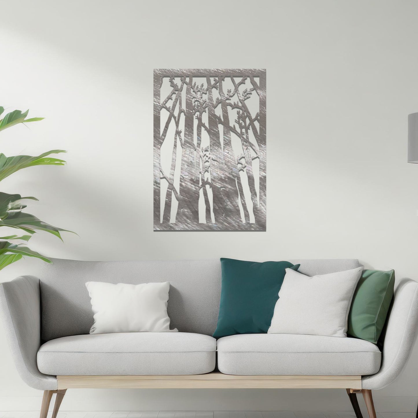 Metal wall art featuring a rectangular design of tall trees with bare branches, showcasing intricate details, displayed on a neutral wall within modern decor.