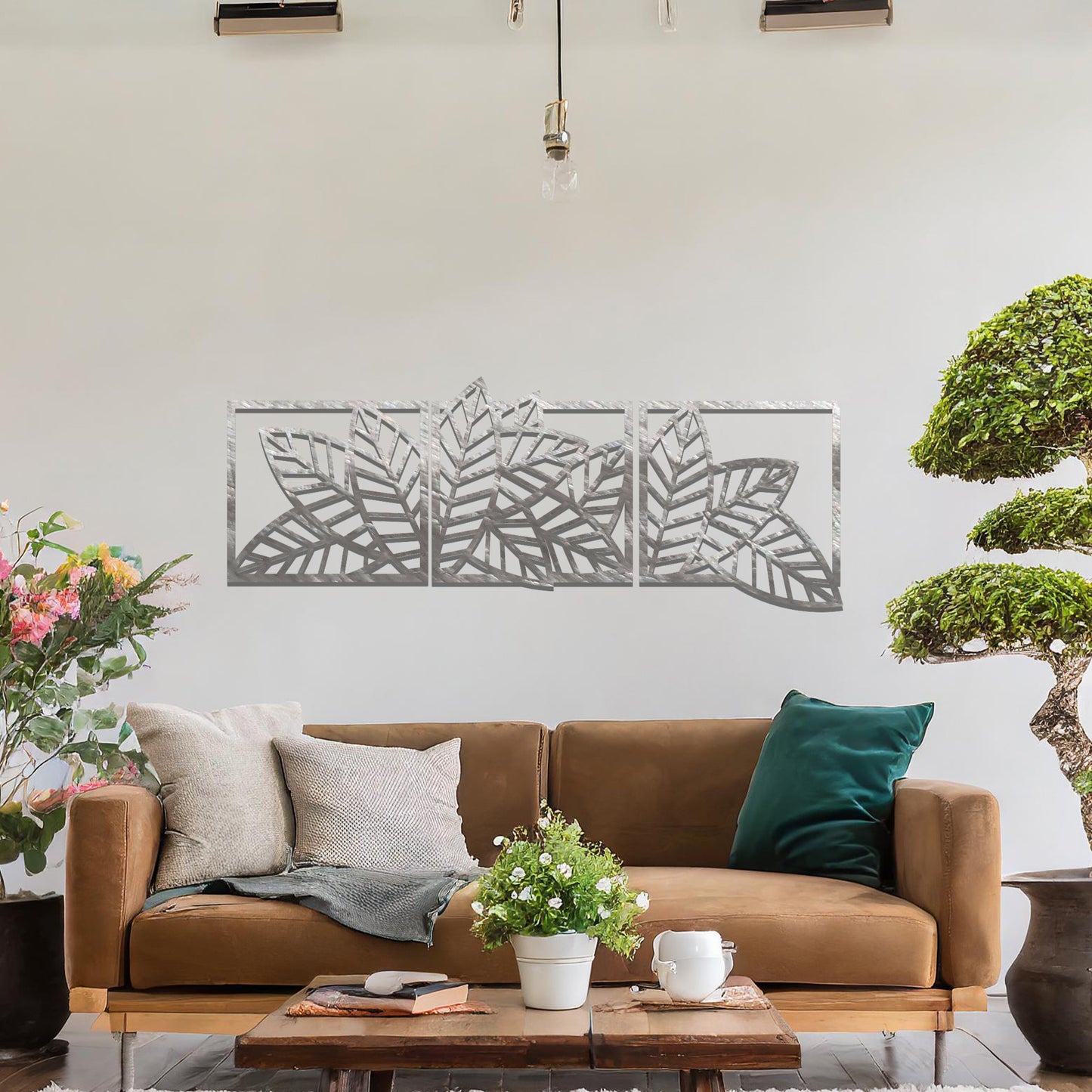 Metal wall art featuring a three-panel design with overlapping leaf patterns, mounted on a neutral wall within modern office decor. The intricate detailing and natural motif of the wall art add an elegant and contemporary touch to the space's aesthetic.