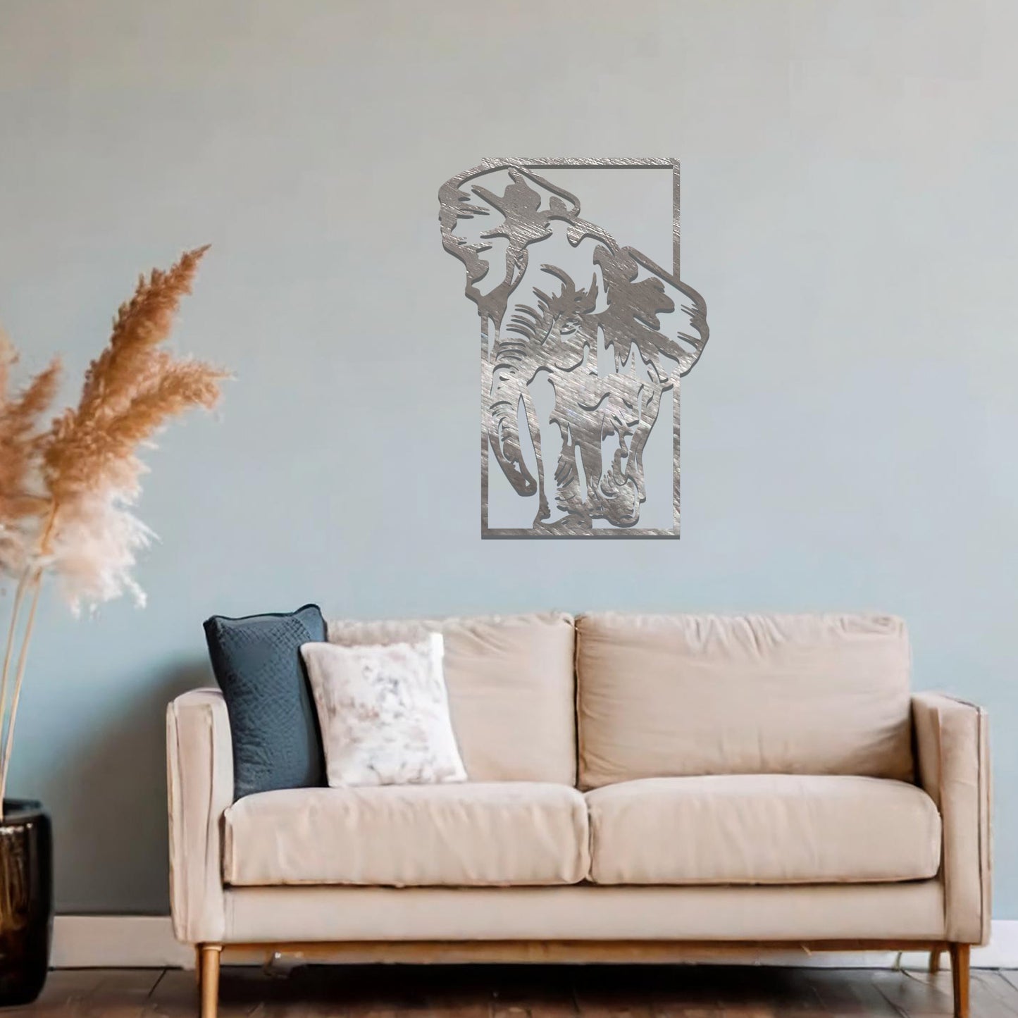 Metal wall art featuring a detailed silhouette of an elephant walking, framed by a rectangular border. The art is placed on a neutral wall in a modern office setting, adding a dynamic and nature-inspired element to the workspace decor.