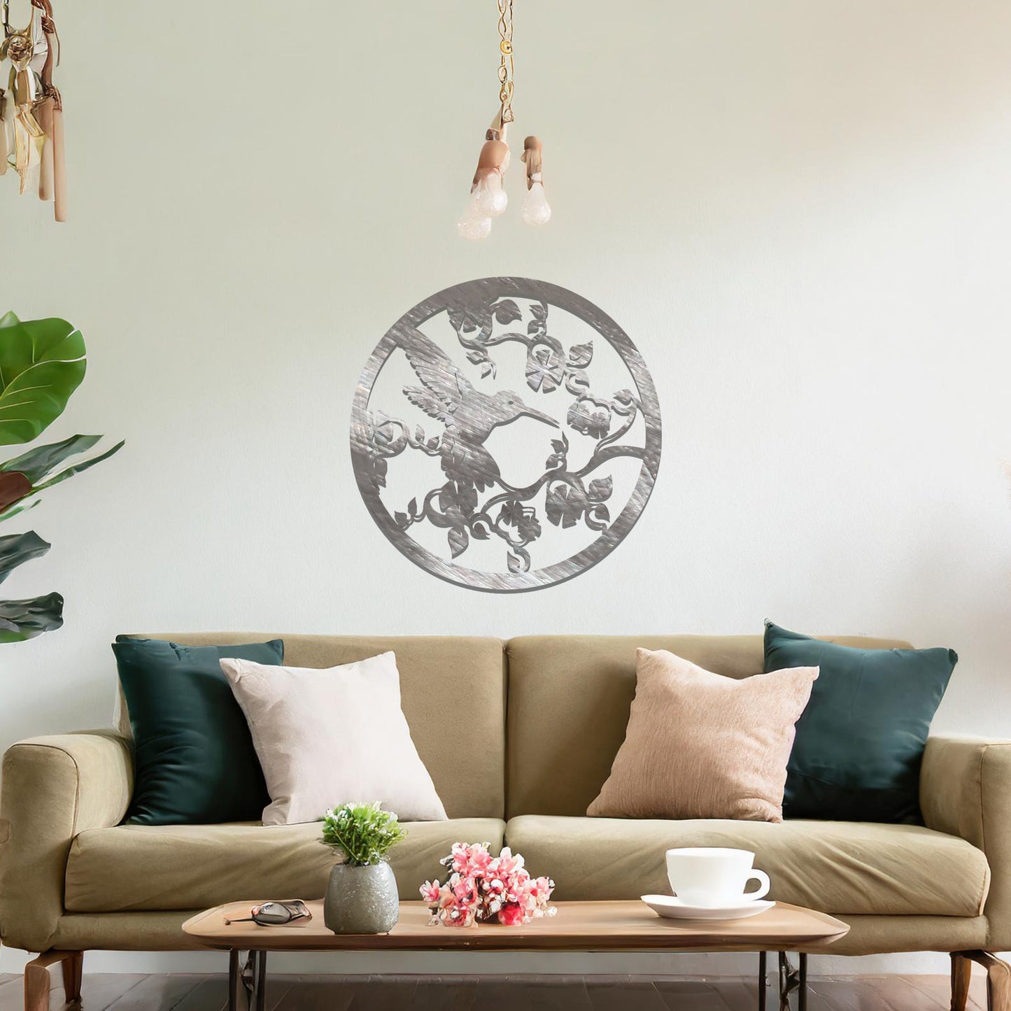 Metal wall art featuring a bird perched on floral vines in a circular design. The intricate patterns of the leaves and branches are beautifully balanced, creating a harmonious look. The art is placed on a neutral wall within modern room decor.