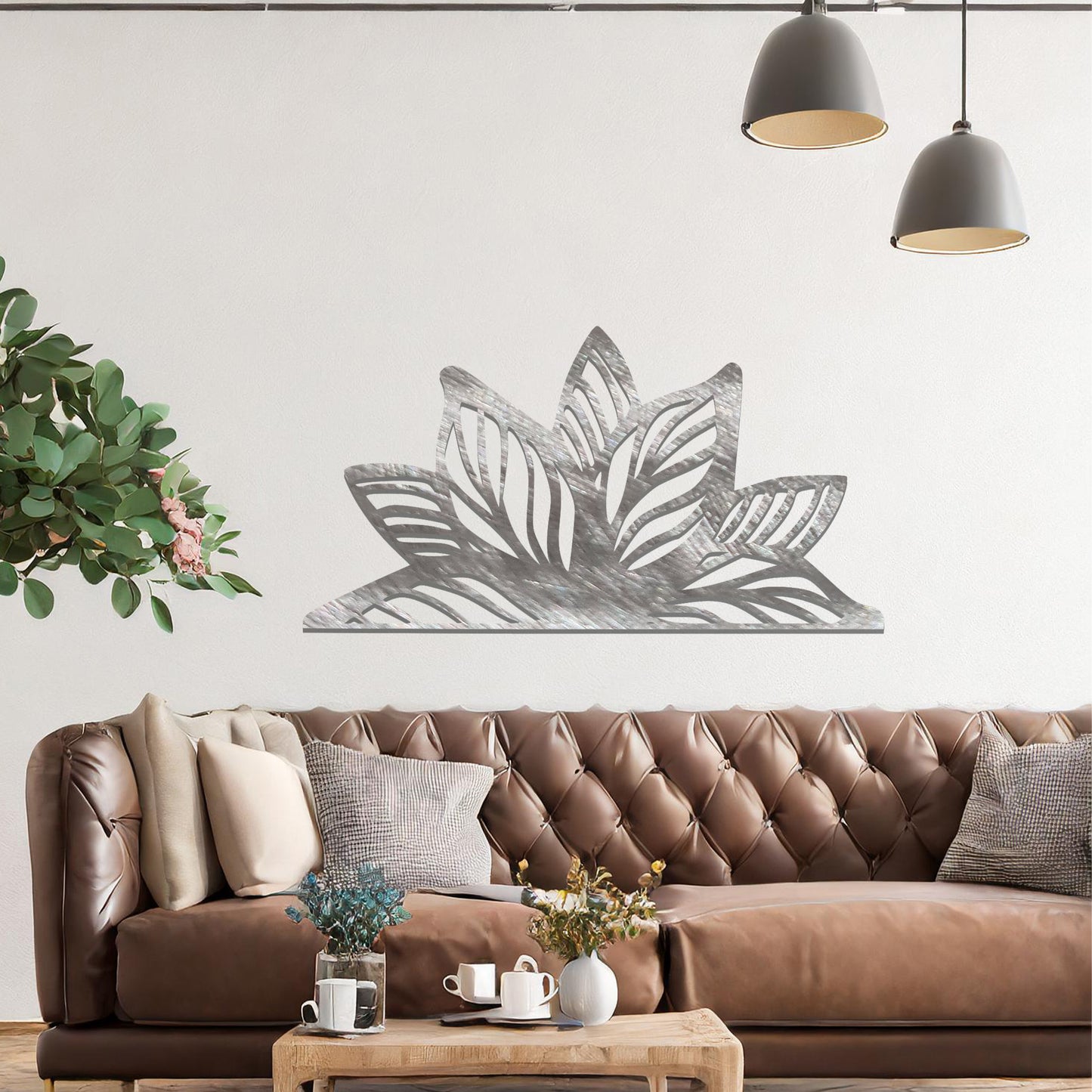 A beautifully intricate metal wall art design featuring a large, stylized lotus flower with detailed, flowing leaves. The art piece is placed on a neutral wall within a modern living room, adding elegance and natural beauty to the space.