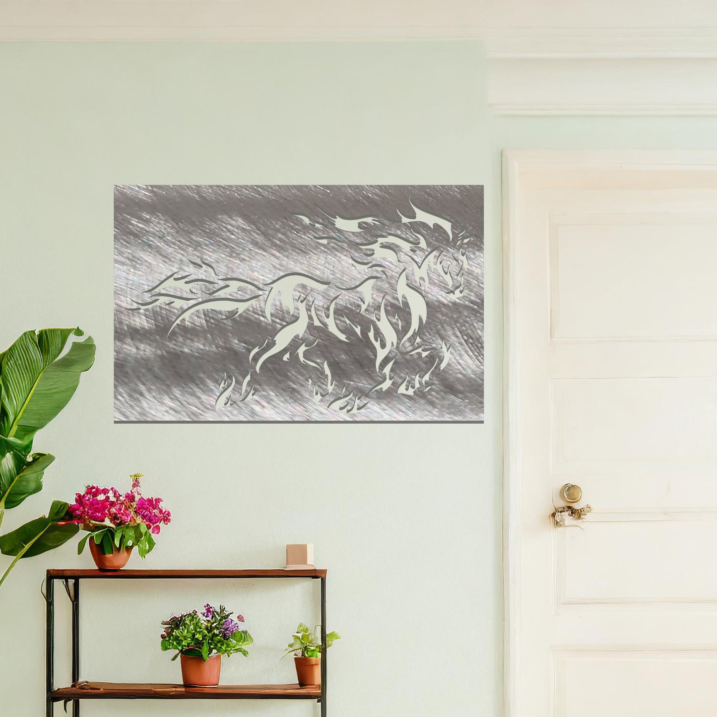 A metal wall art design featuring a powerful horse in motion, with flames integrated into its mane and tail, creating a dynamic and dramatic effect. The artwork is displayed on a neutral wall within a modern setting, enhancing the space's bold, stylish look.