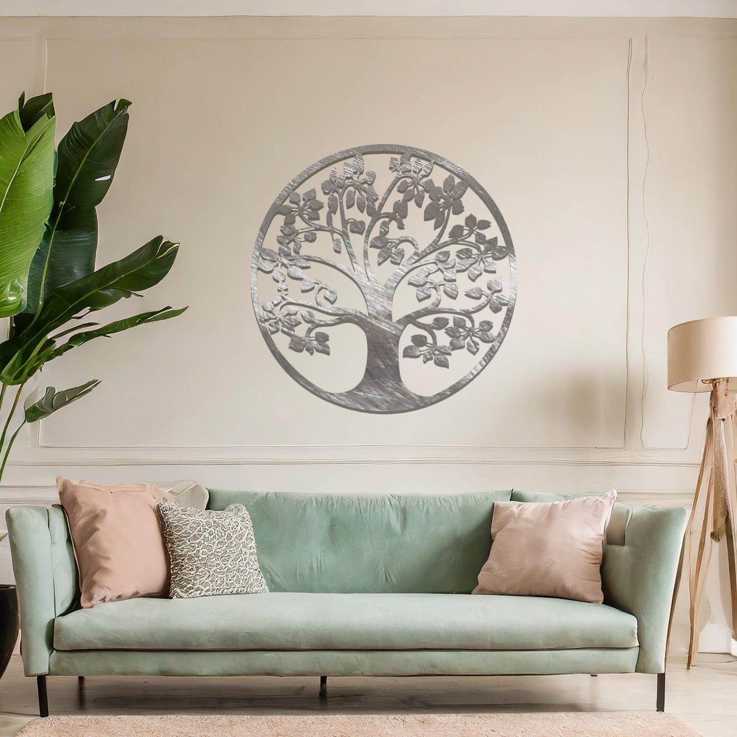 Metal wall art featuring a circular tree design with a detailed trunk, branches, and leaves, crafted with precise laser-cut techniques, displayed on a neutral wall within modern decor.