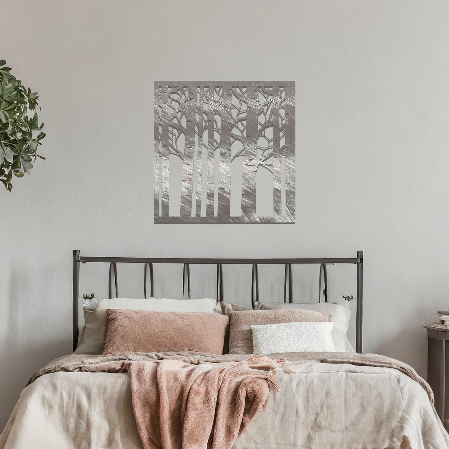 Metal wall art featuring a square design with a detailed forest of tall birch trees, mounted on a neutral wall within modern decor. The intricate silhouette adds a natural and elegant focal point to the room.