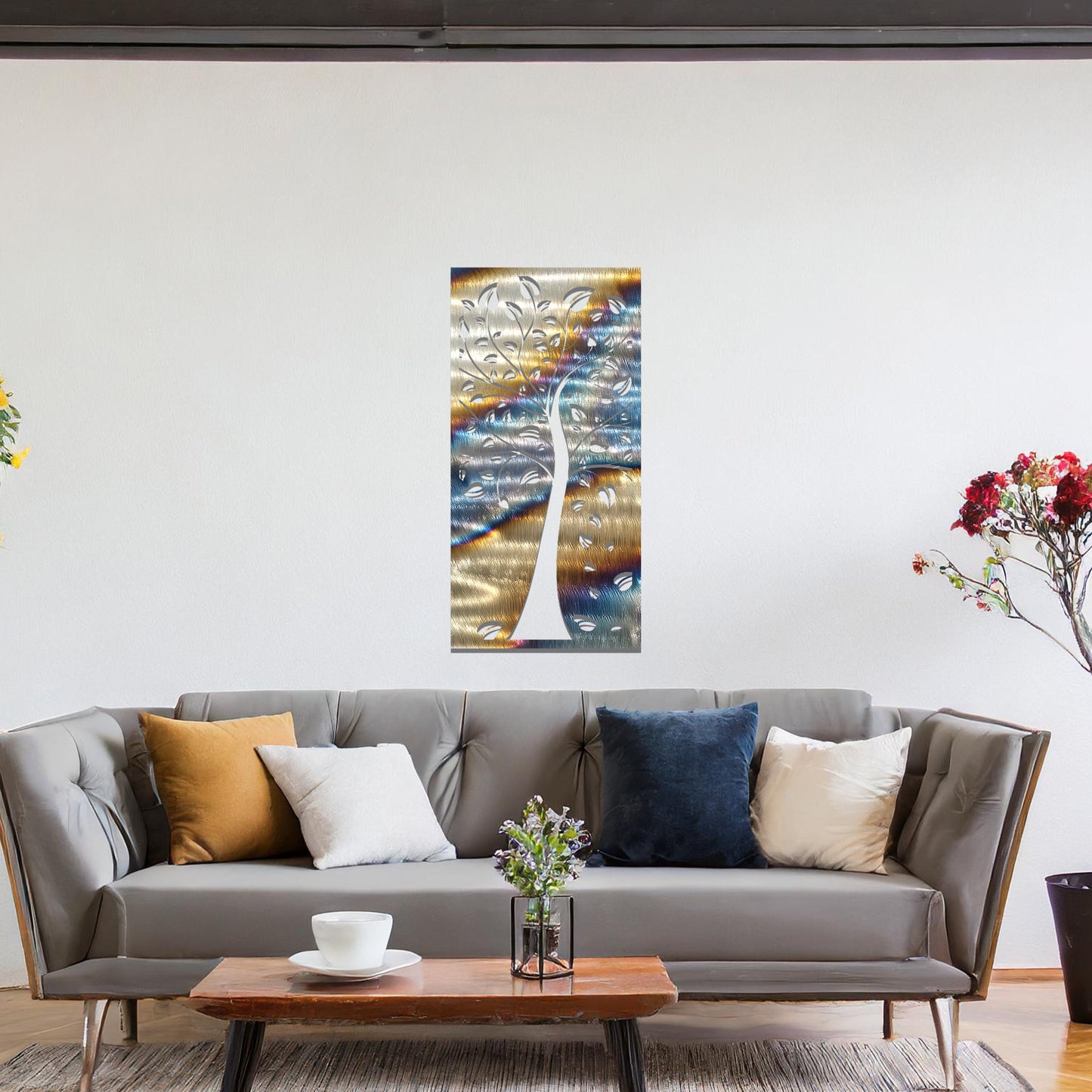 Metal wall art featuring a tree with intricate branches and leaves, enclosed in a vertical rectangular frame. The artwork is displayed on a neutral wall within a modern office setting, complemented by a desk, chair, and indoor plants.