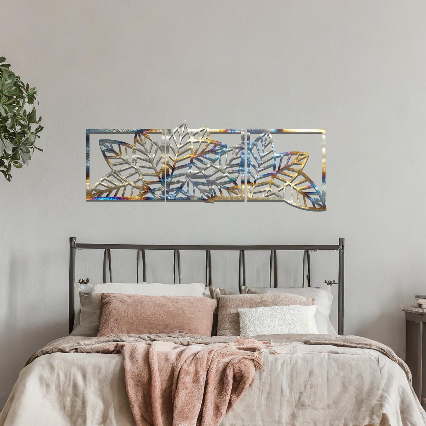 Metal wall art featuring a three-panel design with overlapping leaf patterns, mounted on a neutral wall within modern office decor. The intricate detailing and natural motif of the wall art add an elegant and contemporary touch to the space's aesthetic.