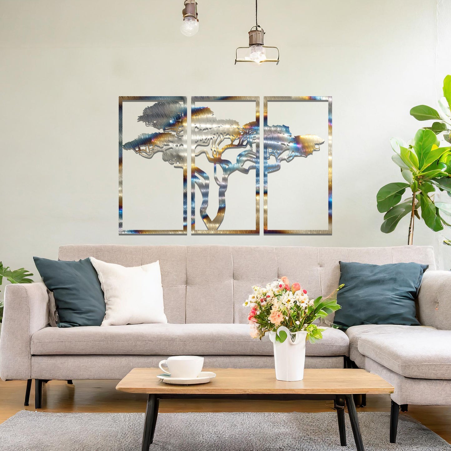 Metal wall art featuring a three-panel design with a stylised tree silhouette, mounted on a neutral wall within a modern artistic setting. The rust finish and detailed tree branches create a natural and calming focal point for the room.
