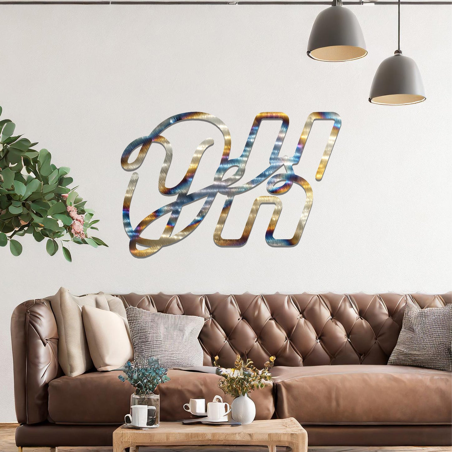 A contemporary metal wall art design featuring the bold, interwoven letters "Oh Yes" in a flowing, cursive style. The artwork is displayed on a neutral wall in a modern room setting.
