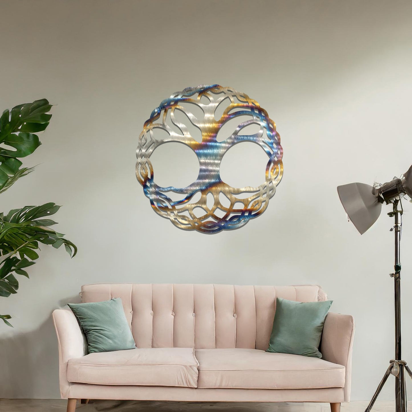 Metal wall art featuring a circular tree of life design with intricately interwoven branches and roots, creating a harmonious and symbolic focal point for the room.