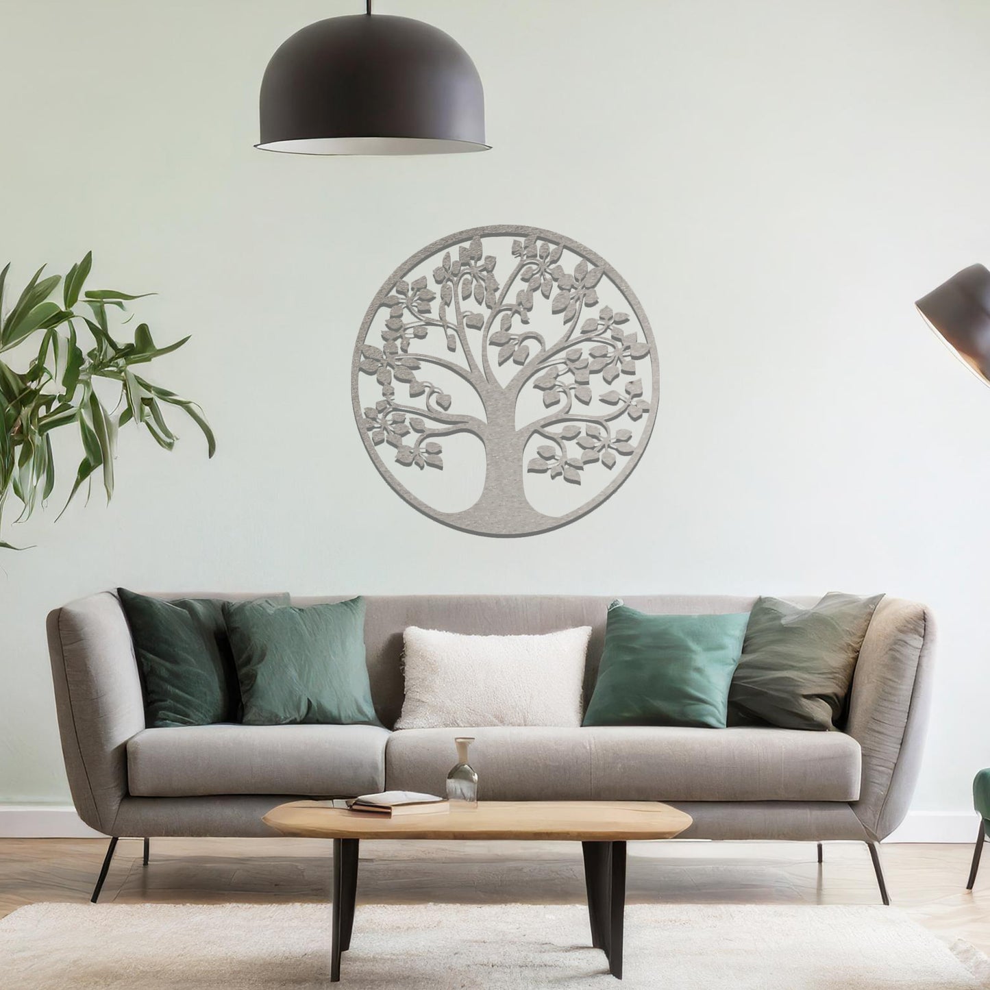 Metal wall art featuring a circular tree design with a detailed trunk, branches, and leaves, crafted with precise laser-cut techniques, displayed on a neutral wall within modern decor.
