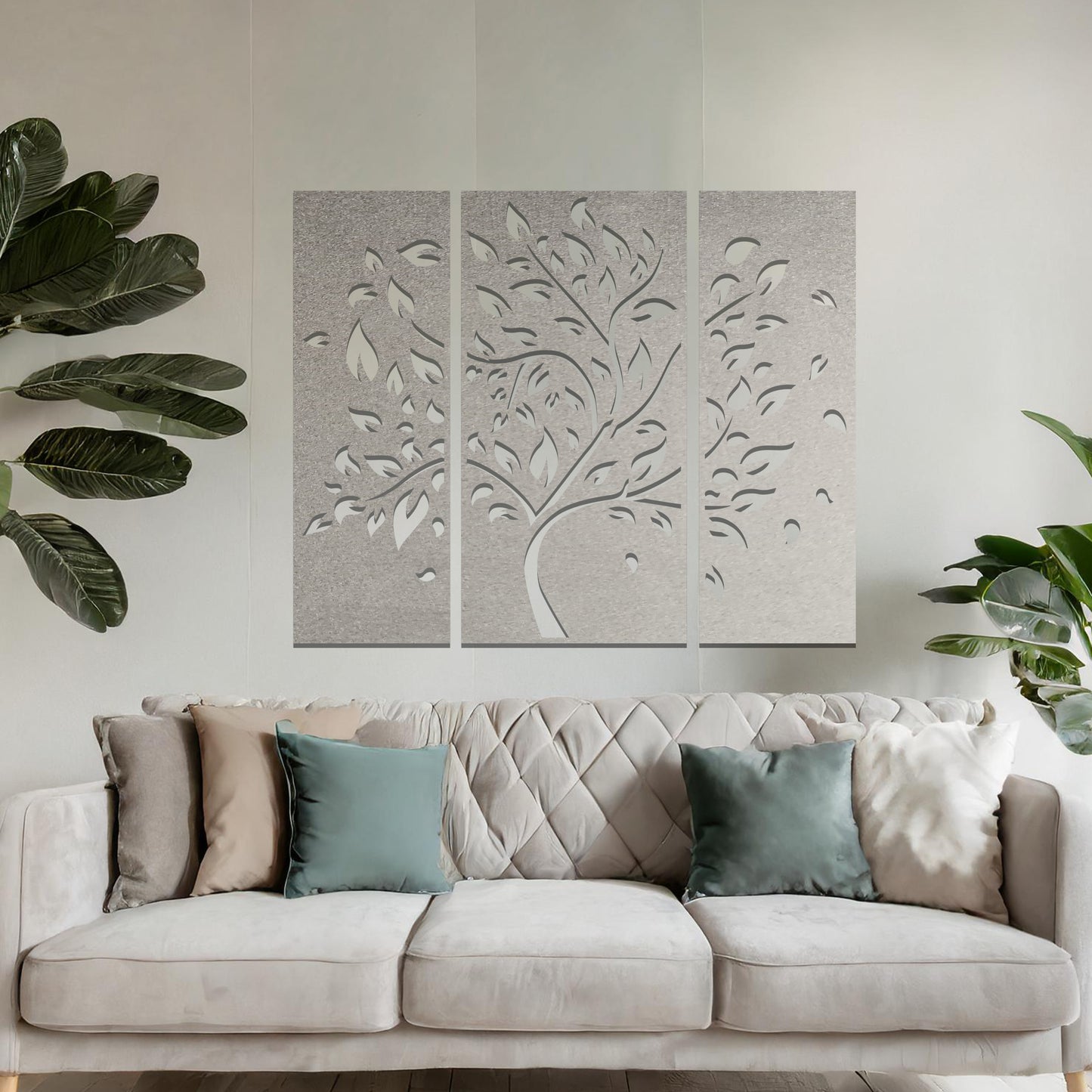 Metal wall art featuring a three-panel tree design with curved branches and delicate leaves, crafted with precise laser-cut detailing, displayed on a neutral wall within modern decor.