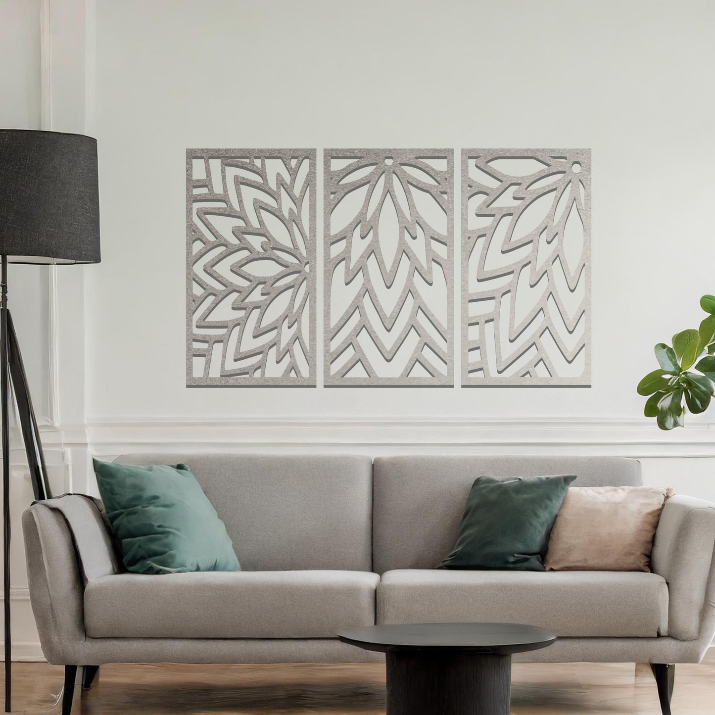 Metal wall art featuring a three-panel design with floral-inspired geometric patterns, crafted with precise laser-cut detailing, displayed on a neutral wall within modern decor.