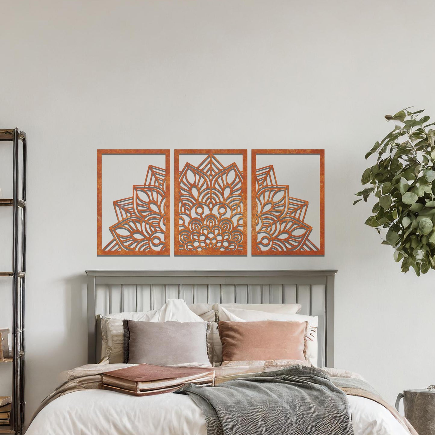 A metal wall art design featuring a detailed mandala pattern, divided into three panels. The intricate floral design is framed within each section. The art is displayed on a neutral wall in a modern bedroom, adding elegance to the peaceful setting.