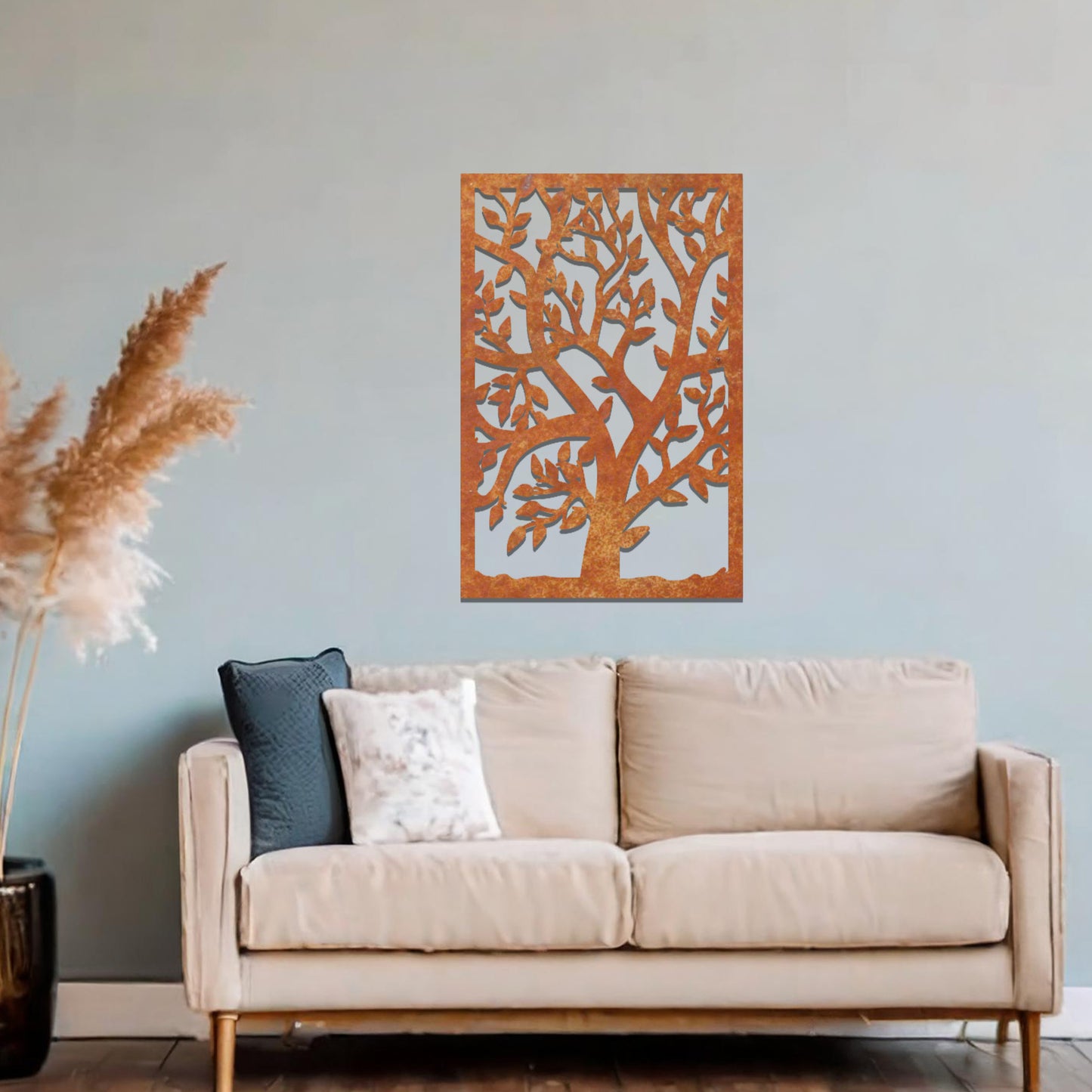 Metal wall art featuring a tree with detailed branches and leaves, enclosed in a rectangular frame. The artwork is displayed on a neutral wall within a modern office space, complemented by a stylish desk, chair, and greenery.