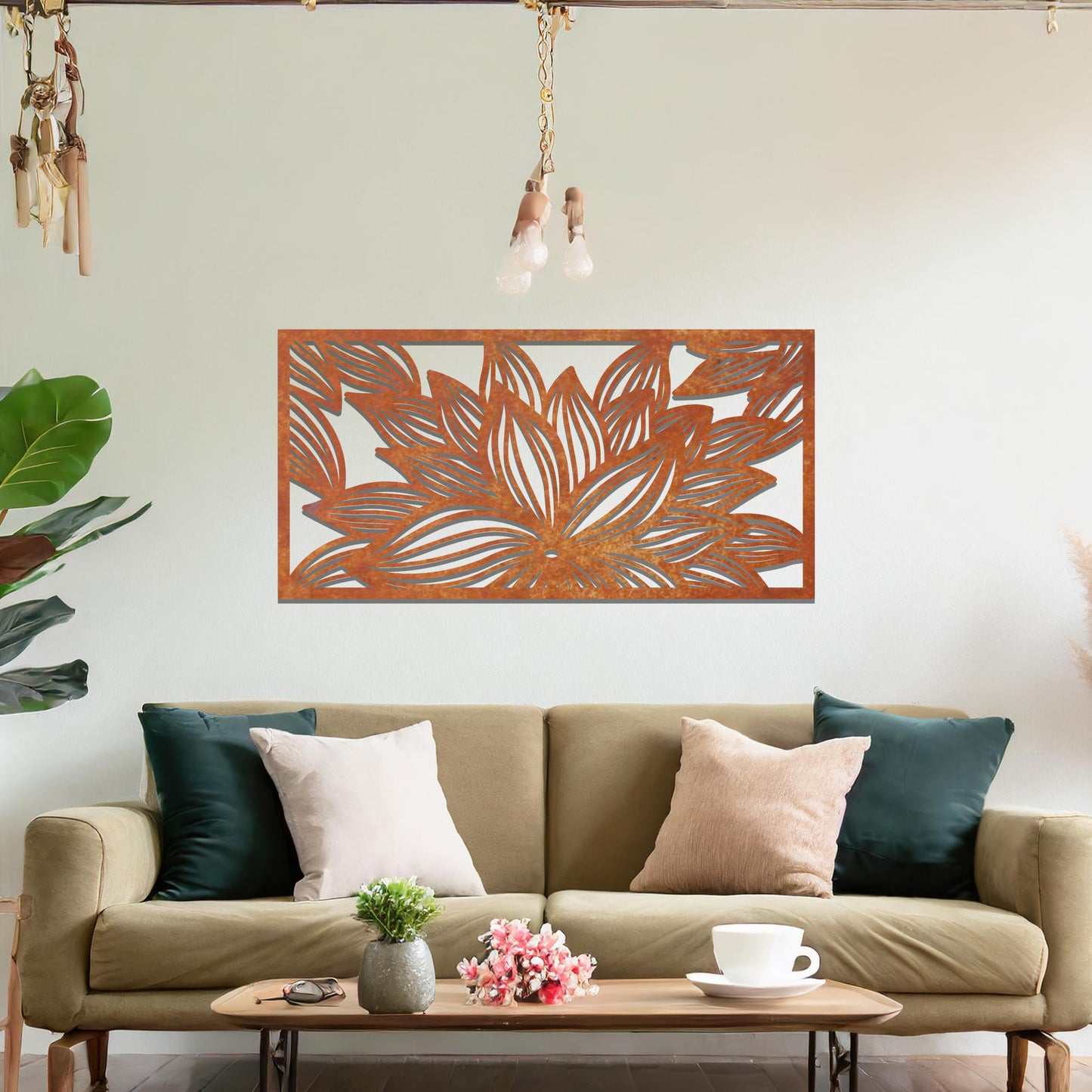 A metal wall art design showcasing a lotus flower with detailed, flowing petals. The design is framed within a rectangular shape. The art is displayed on a neutral wall within a modern living room setting, complementing the room's elegant decor.