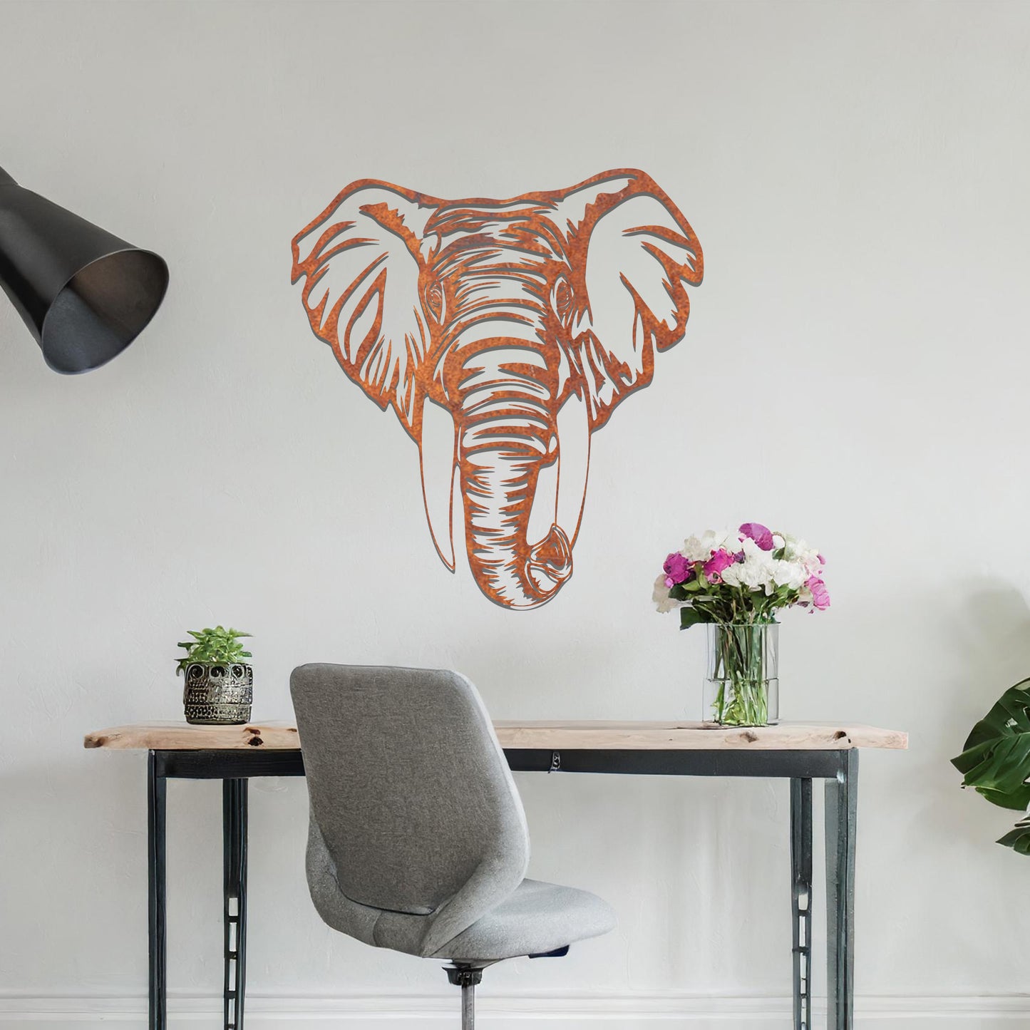 Metal wall art featuring a detailed elephant head design with intricate lines and realistic features, crafted with precise laser-cut techniques, displayed on a neutral wall within modern decor.