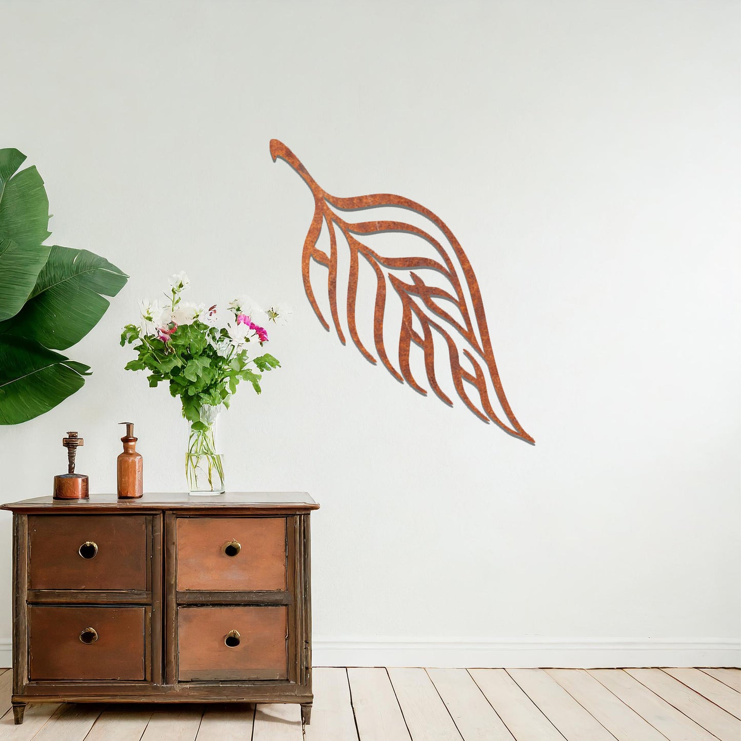 Metal wall art featuring a stylised leaf design with intricate linework and the word "Allah" seamlessly incorporated, mounted on a neutral wall within modern room decor. The elegant craftsmanship and spiritual motif make it a striking focal point in the space.
