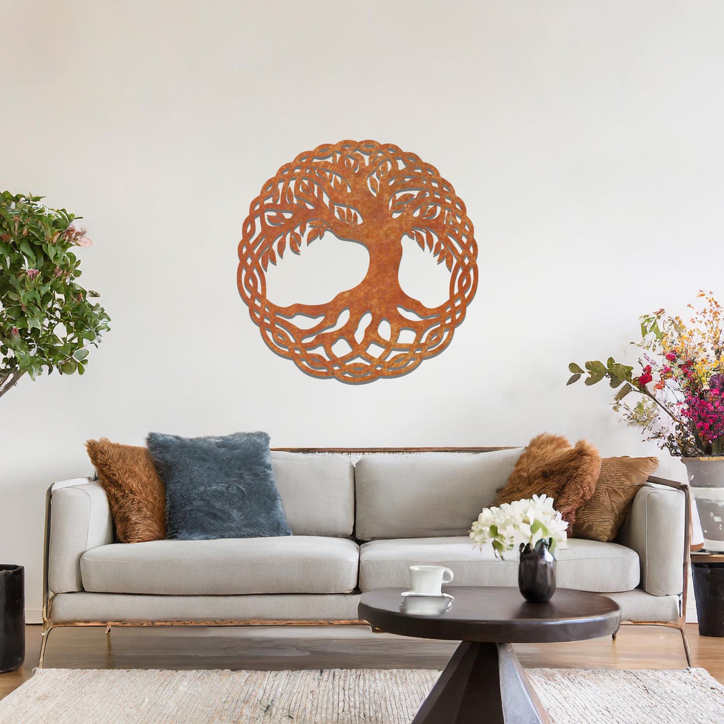 Metal wall art featuring a circular tree of life design with intricate roots and branches enclosed in a detailed border, crafted with precise laser-cut techniques, displayed on a neutral wall within modern decor.