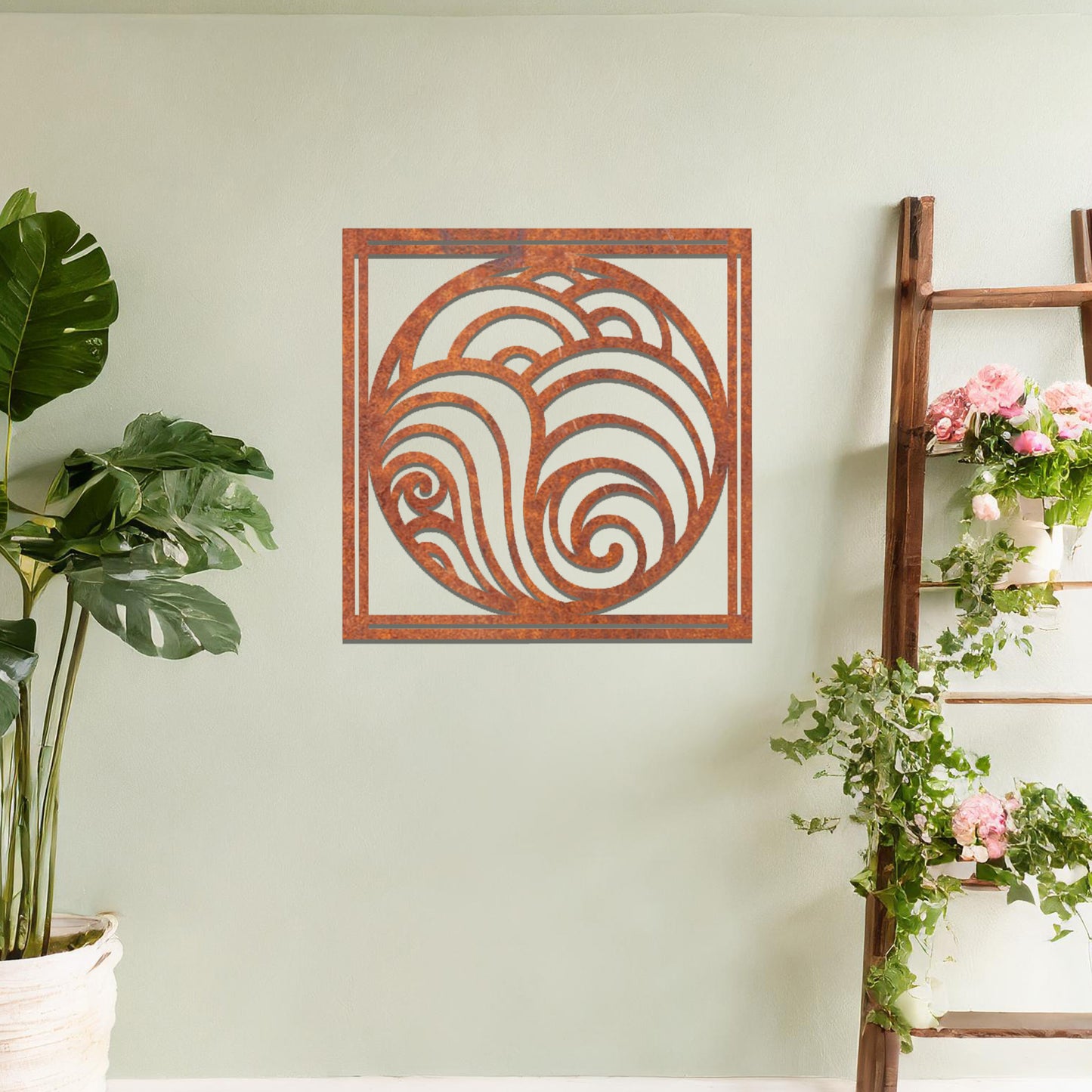 Metal wall art featuring a square design with swirling wave patterns inside a circular frame, mounted on a neutral wall within modern decor. The flowing lines and fluid shapes create a peaceful and dynamic focal point, enhancing the space.
