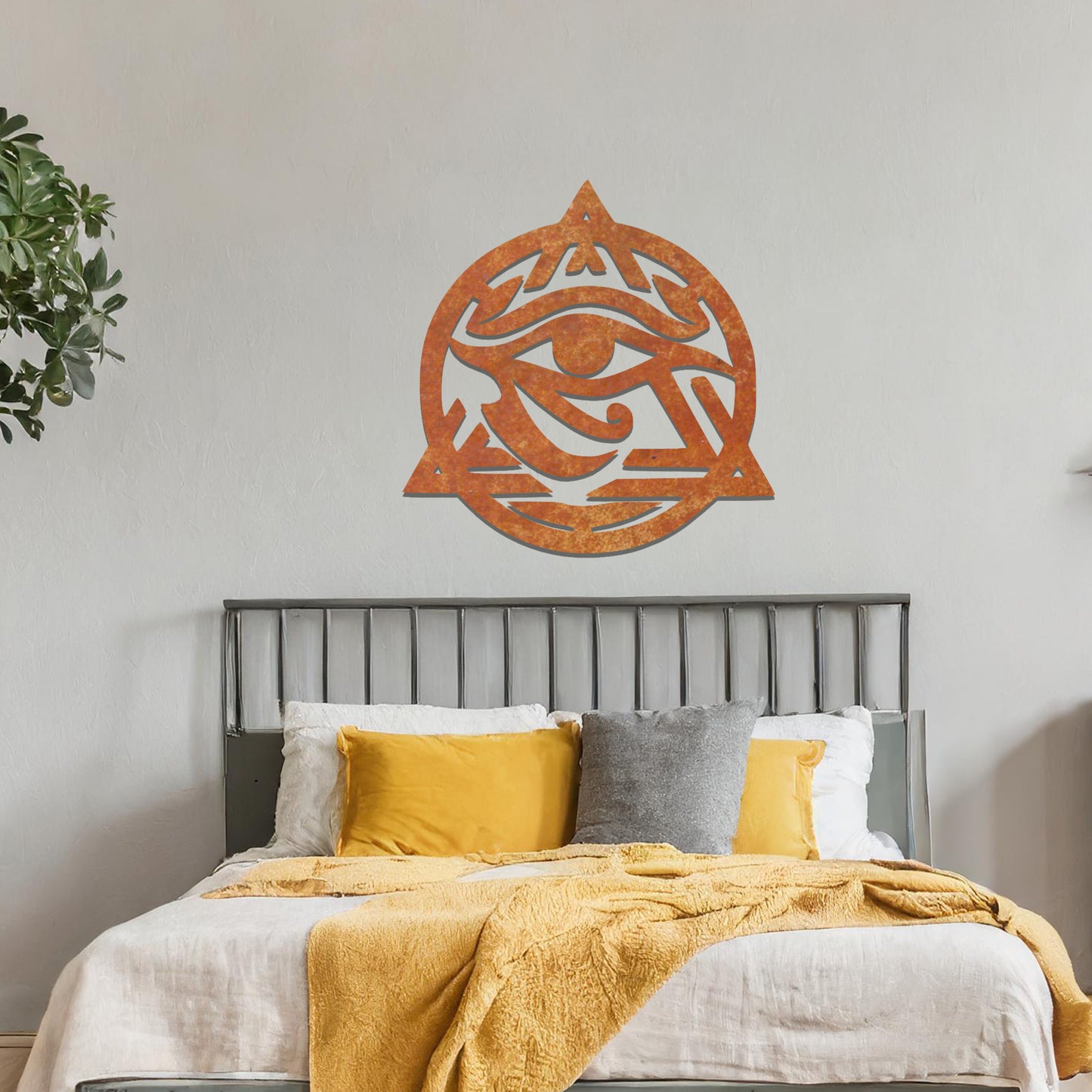 Metal wall art featuring an intricate design of the Eye of Horus, enclosed within a geometric triangle and circle. The artwork is placed on a neutral wall in a modern living room setting, adding to the contemporary decor.