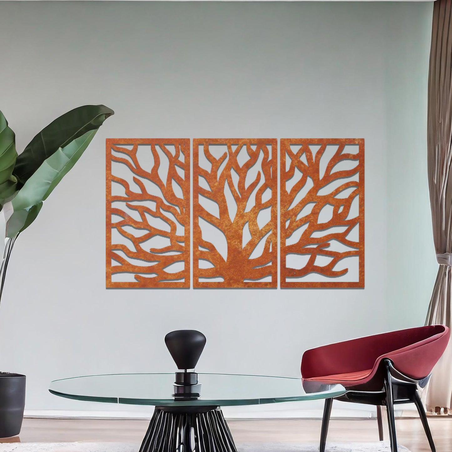 Metal wall art featuring a three-panel design of a tree with intricate branching patterns, crafted with precise laser-cut detailing, placed on a neutral wall within modern decor.