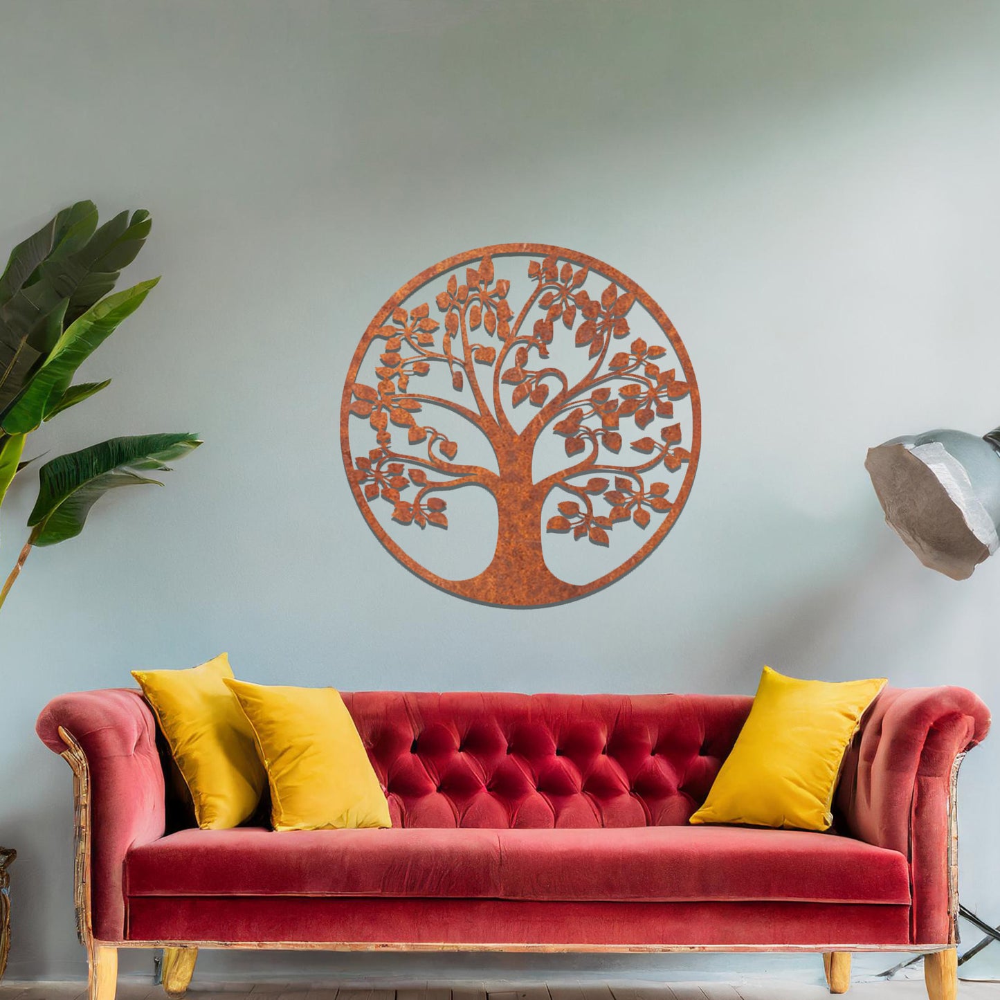 Metal wall art featuring a circular tree design with a detailed trunk, branches, and leaves, crafted with precise laser-cut techniques, displayed on a neutral wall within modern decor.