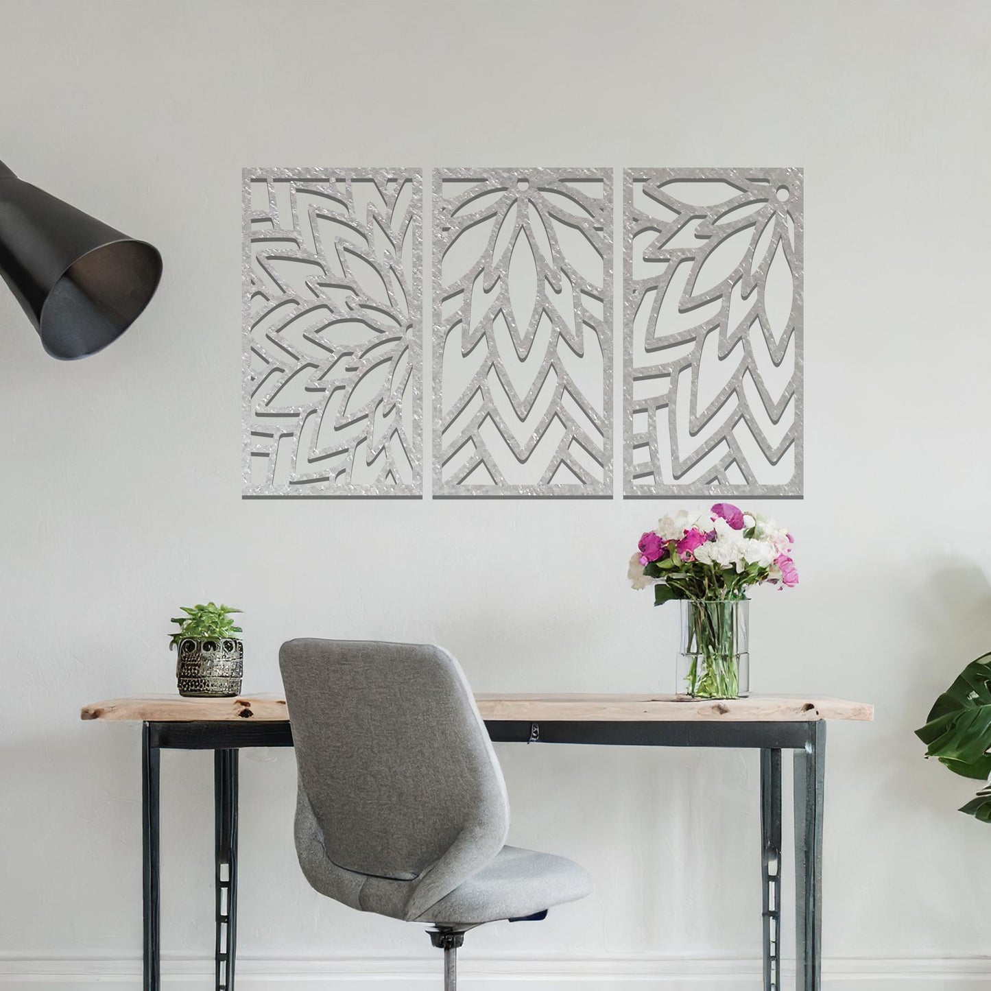 Metal wall art featuring a three-panel design with floral-inspired geometric patterns, crafted with precise laser-cut detailing, displayed on a neutral wall within modern decor.