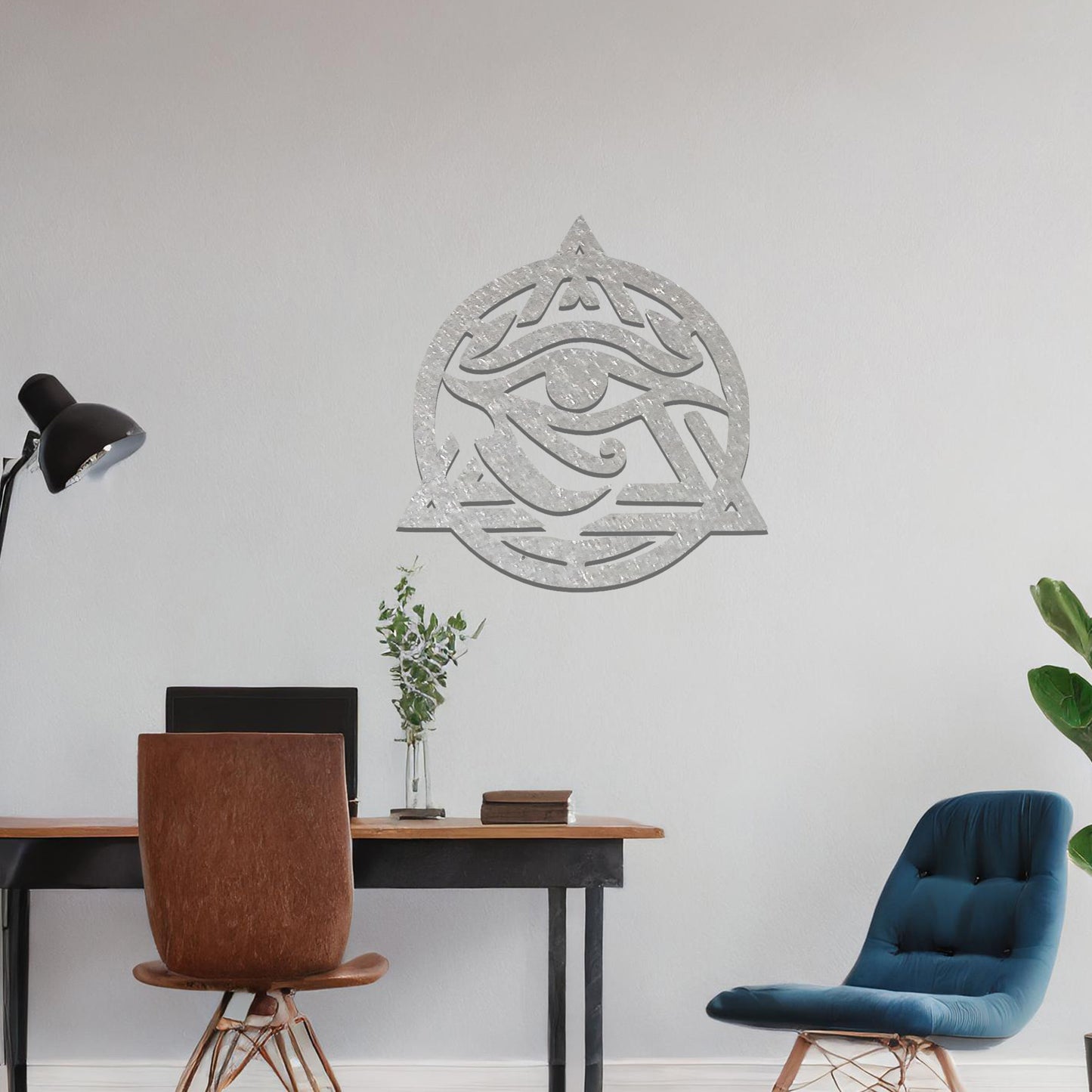 Metal wall art featuring an intricate design of the Eye of Horus, enclosed within a geometric triangle and circle. The artwork is placed on a neutral wall in a modern living room setting, adding to the contemporary decor.