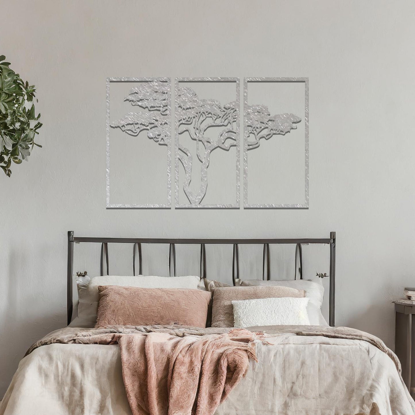 Metal wall art featuring a three-panel design with a stylised tree silhouette, mounted on a neutral wall within a modern artistic setting. The rust finish and detailed tree branches create a natural and calming focal point for the room.