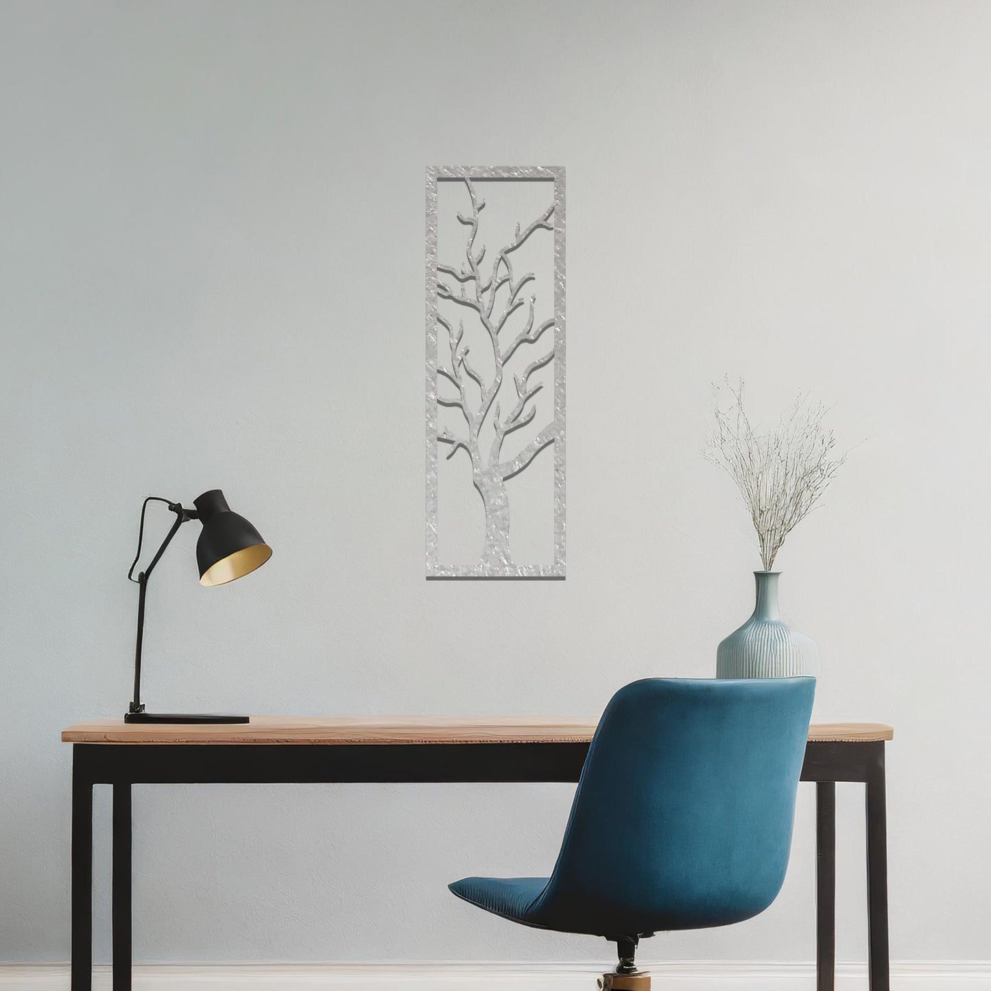 Metal wall art featuring a vertical design of a bare tree with intricate branches, mounted on a neutral wall within elegant room decor. The minimalist silhouette of the tree adds a sophisticated, natural focal point to the space.