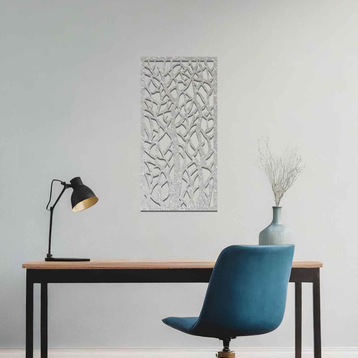 Metal wall art featuring a rectangular design with intricate tree branches and abstract shapes, creating a visually captivating and artistic focal point for the room.
