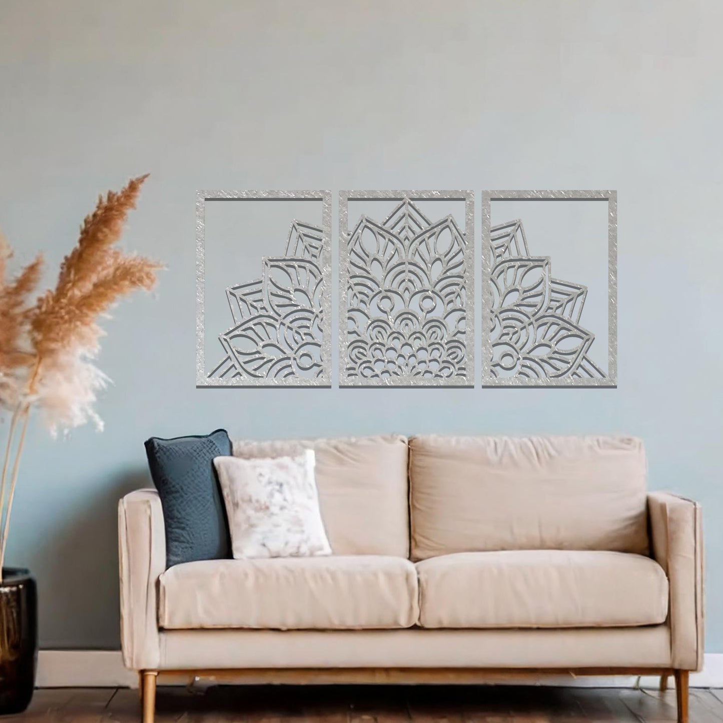 A metal wall art design featuring a detailed mandala pattern, divided into three panels. The intricate floral design is framed within each section. The art is displayed on a neutral wall in a modern bedroom, adding elegance to the peaceful setting.