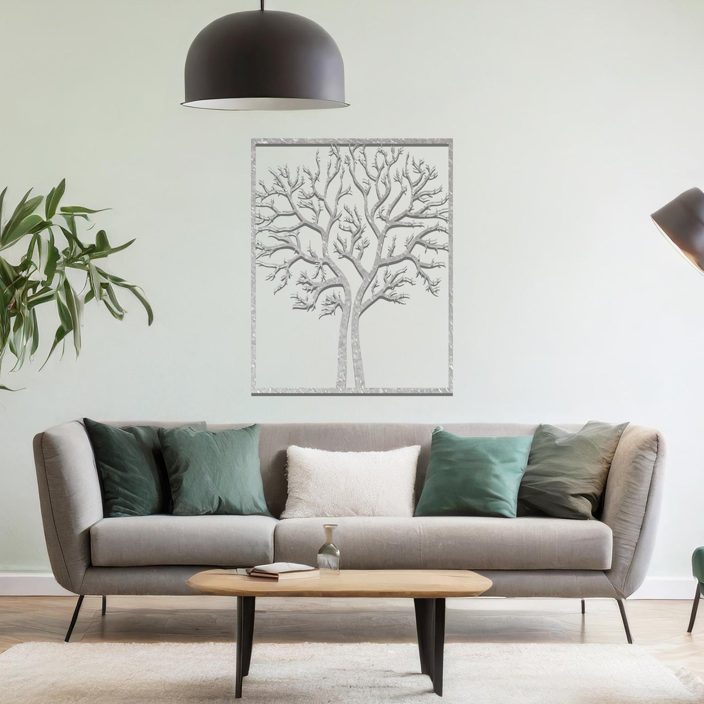 Metal wall art featuring a framed tree design with intricate, bare branches, crafted with precise laser-cut techniques, displayed on a neutral wall within modern decor.