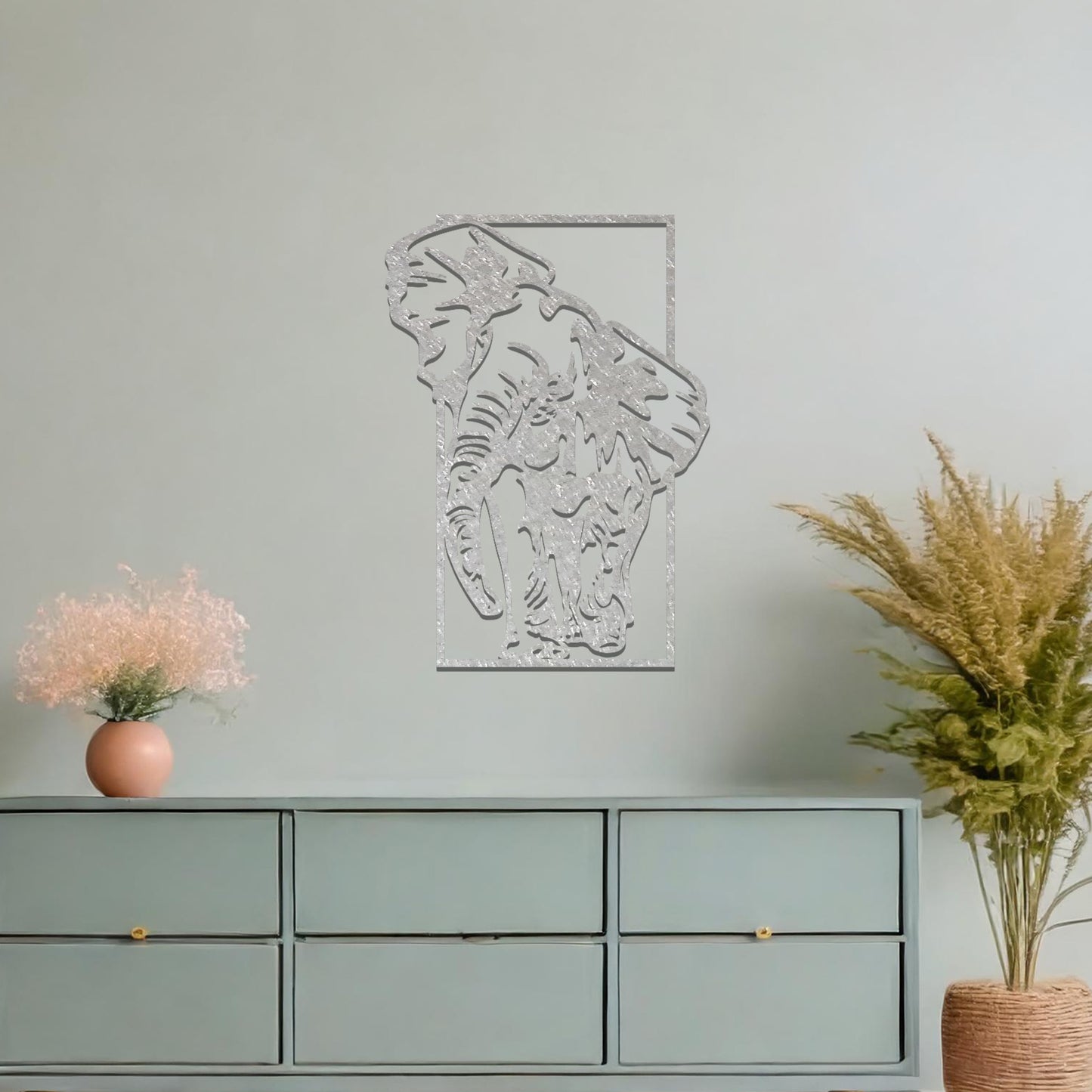 Metal wall art featuring a detailed silhouette of an elephant walking, framed by a rectangular border. The art is placed on a neutral wall in a modern office setting, adding a dynamic and nature-inspired element to the workspace decor.