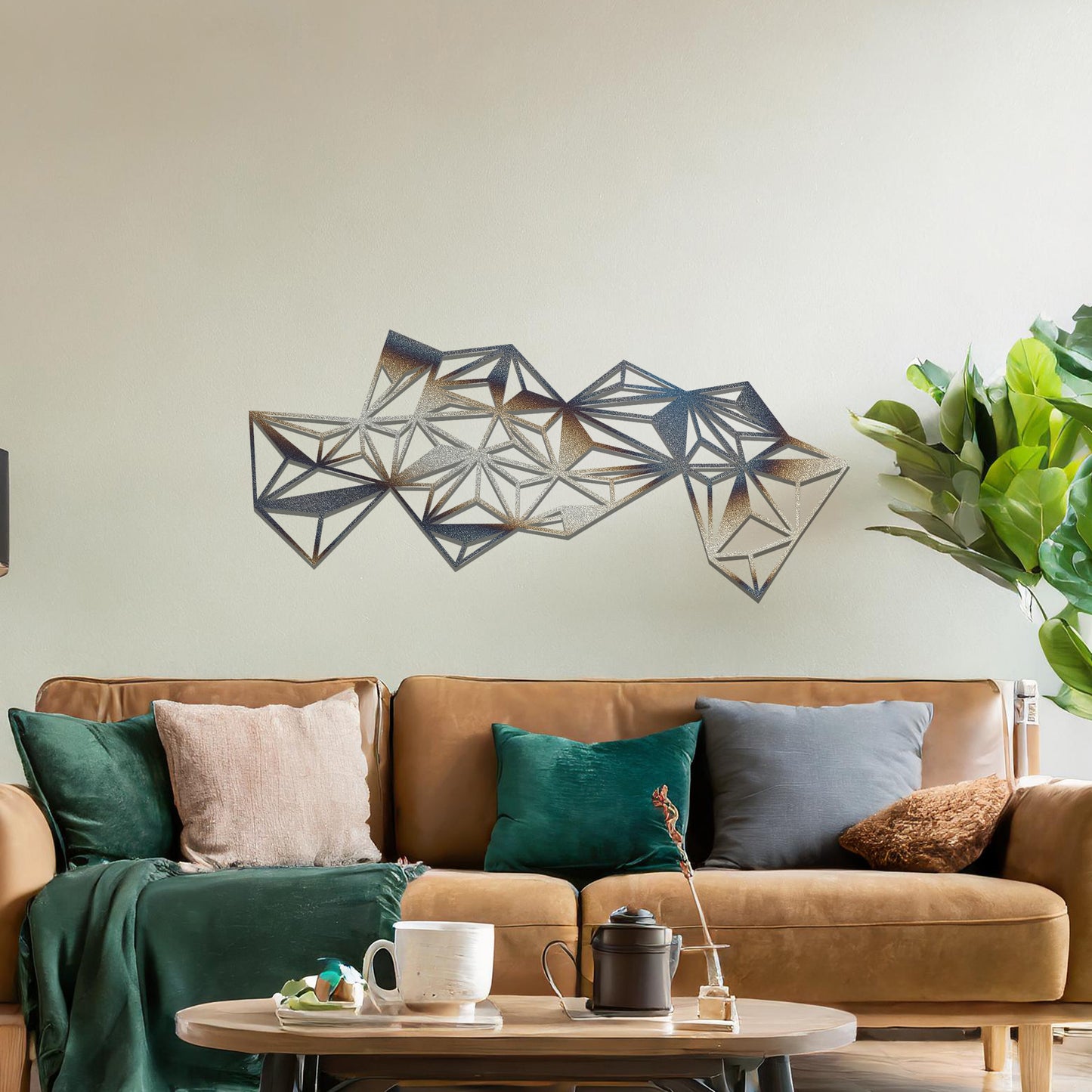 Metal wall art featuring an abstract geometric design with multiple interconnected triangular shapes, creating a dynamic, faceted pattern. The art is placed on a neutral wall within a modern room, complementing the vibrant decor with plants and furniture.