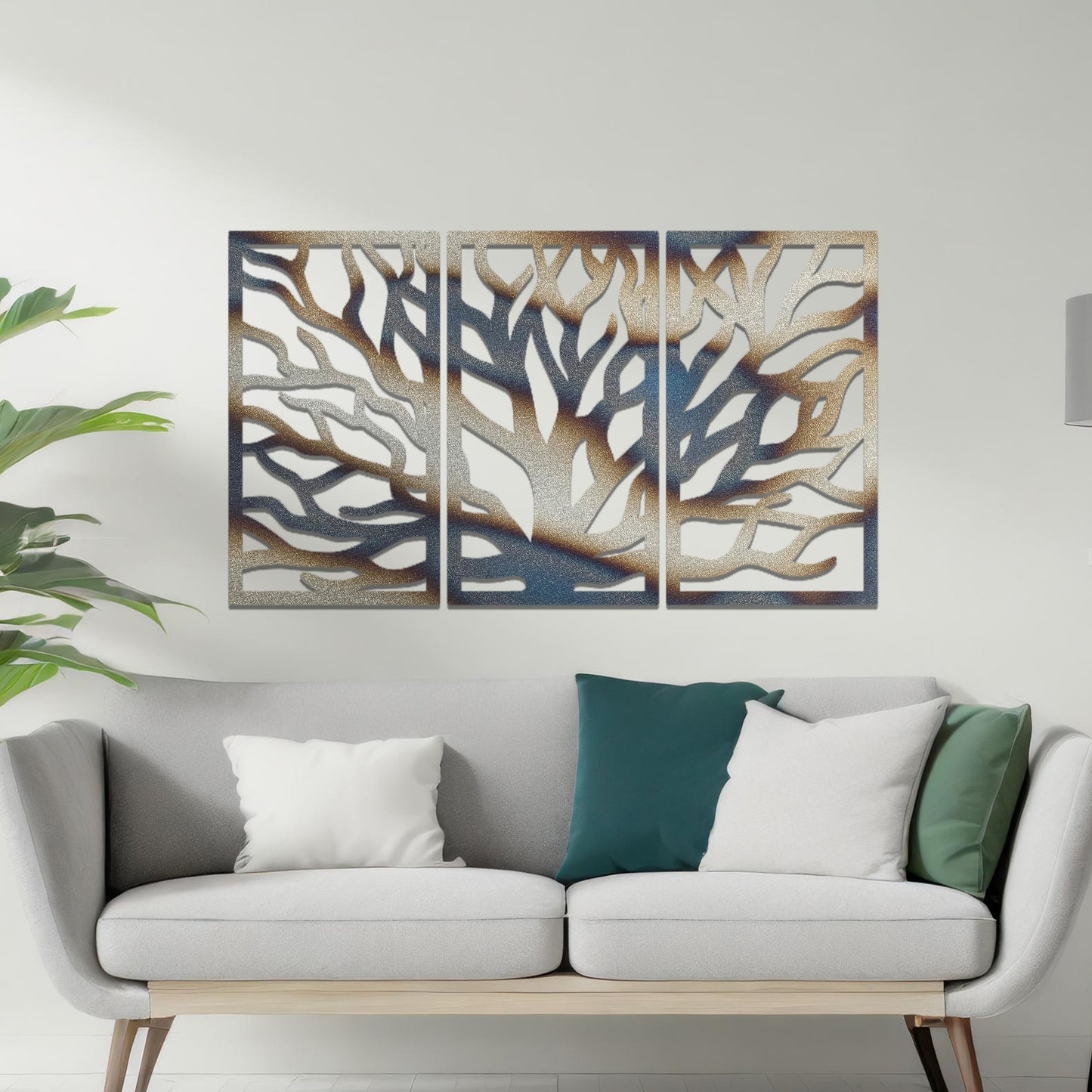 Metal wall art featuring a three-panel design of a tree with intricate branching patterns, crafted with precise laser-cut detailing, placed on a neutral wall within modern decor.
