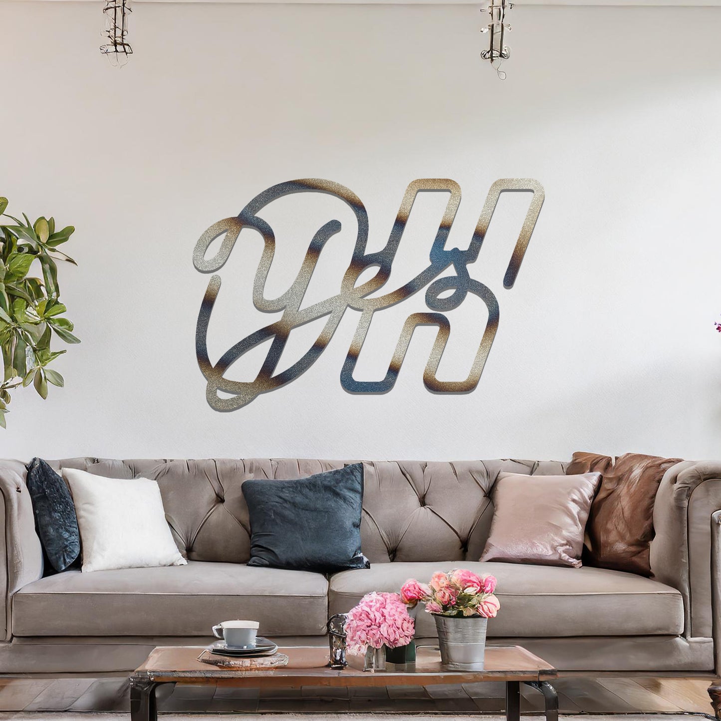 A contemporary metal wall art design featuring the bold, interwoven letters "Oh Yes" in a flowing, cursive style. The artwork is displayed on a neutral wall in a modern room setting.