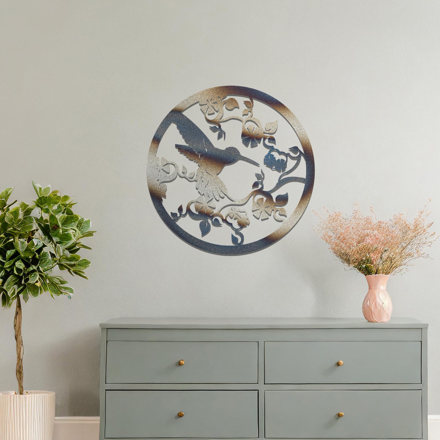 Metal wall art featuring a bird perched on floral vines in a circular design. The intricate patterns of the leaves and branches are beautifully balanced, creating a harmonious look. The art is placed on a neutral wall within modern room decor.