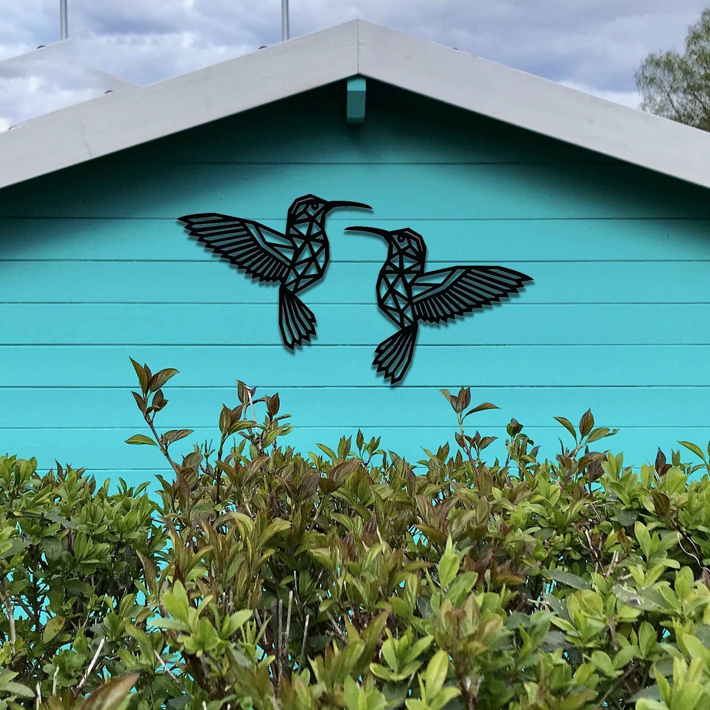 Metal garden decoration featuring two hummingbirds with geometric patterns in a dynamic pose, intricately designed to add elegance and a nature-inspired artistic touch to outdoor walls, fences, or garden sheds